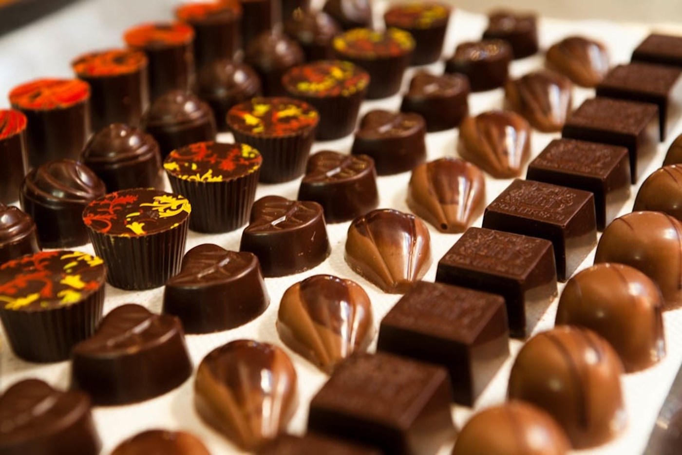 A variety of truffles and artisan chocolates lined up. 