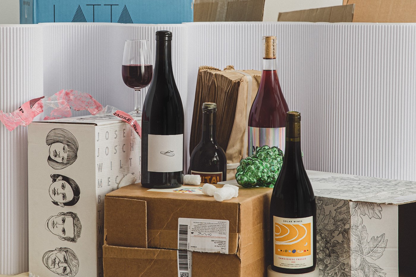 A selection of wines sitting atop an array of different cardboard boxes.