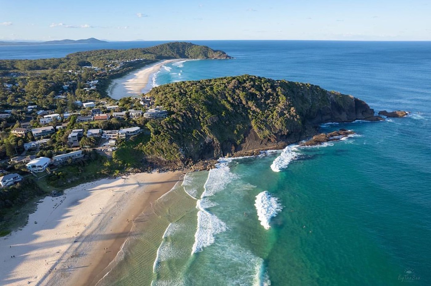 A drone shot of the beautifully blue Bluey's Beach and small town and parkland in NSW