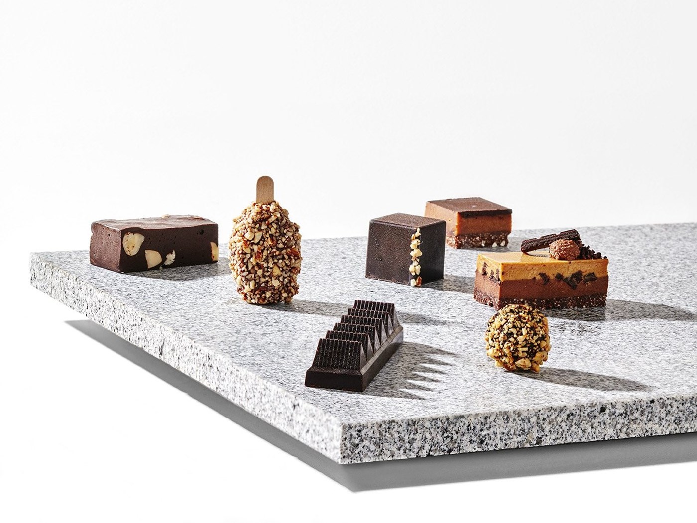An array of Pana chocolates displayed on a marble slab. 
