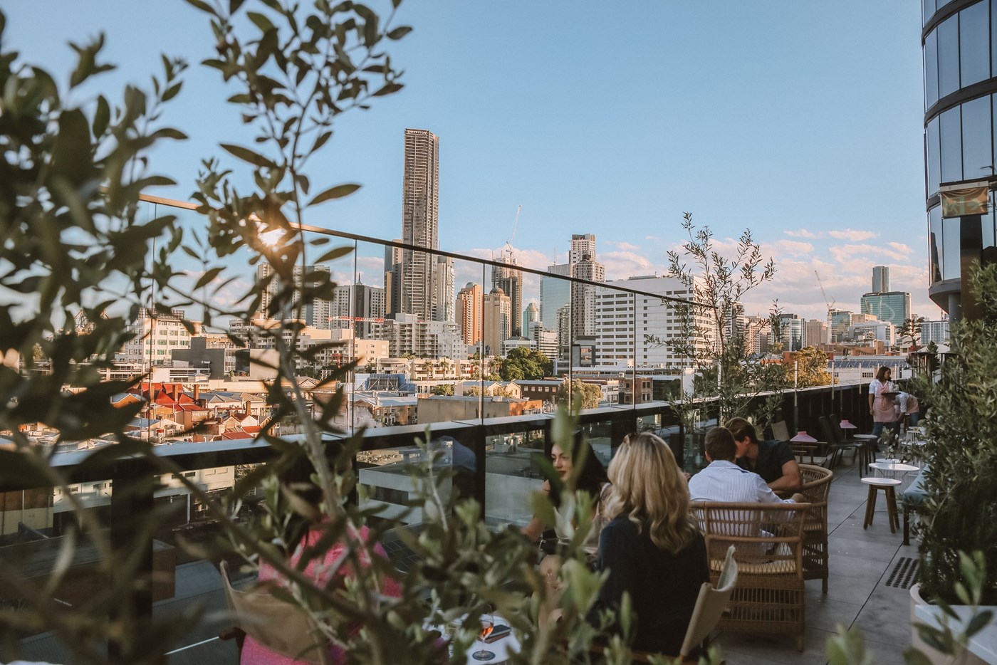 A shot of the exterior rooftop bar terrace with the Brisbane city skyline in the background.