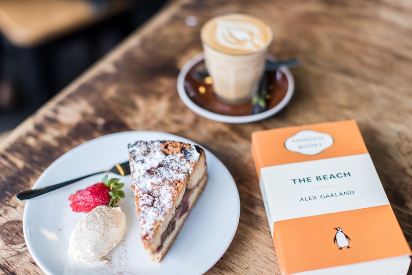 Pie, coffee, and a book on a table at Gertrude and Alice Bookshop Bondi Beach Sydney