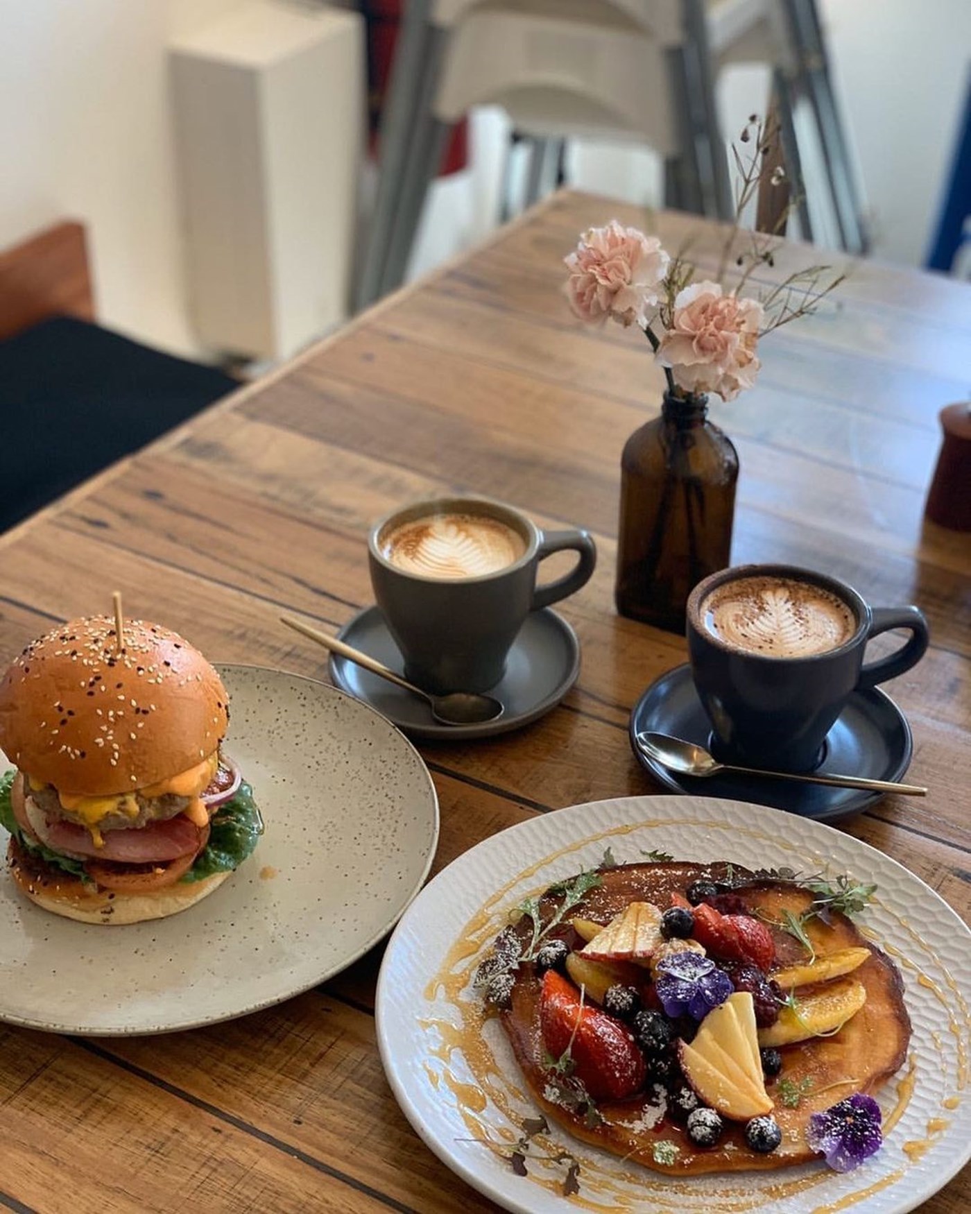 A plate of pancakes and a loaded burger and 2 lattes at Big Tree House Café Parramatta