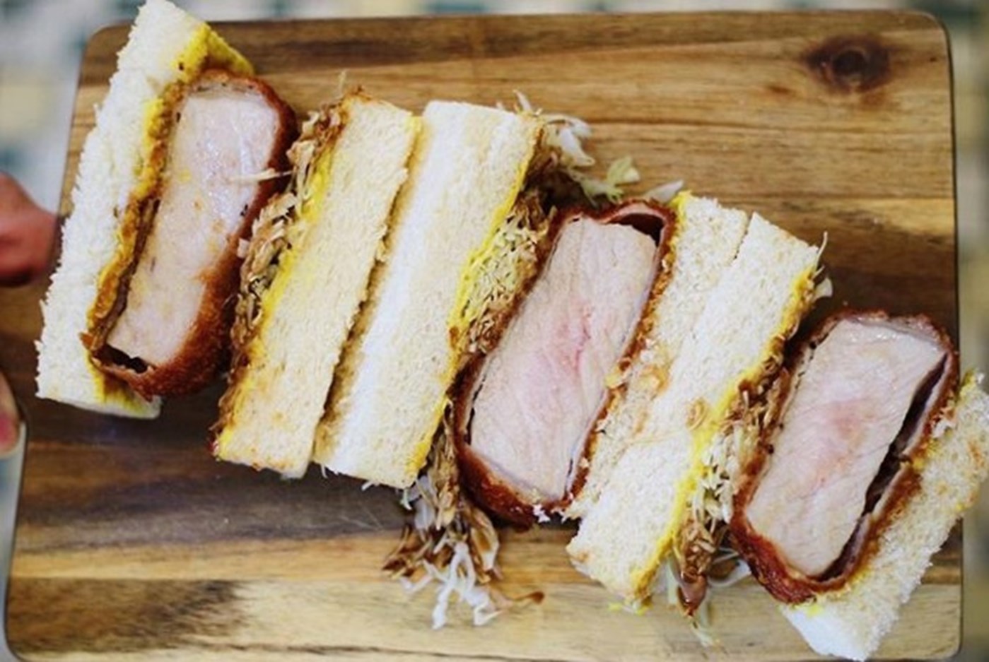A trio of Katsu Sandwich severed on a wooden board by Café Oratnek Redfern Sydney