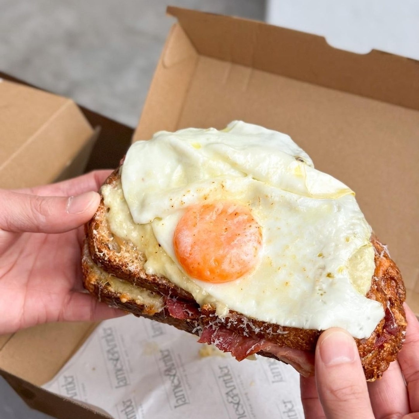 A toasted croque madame sandwich with a fried egg on top 