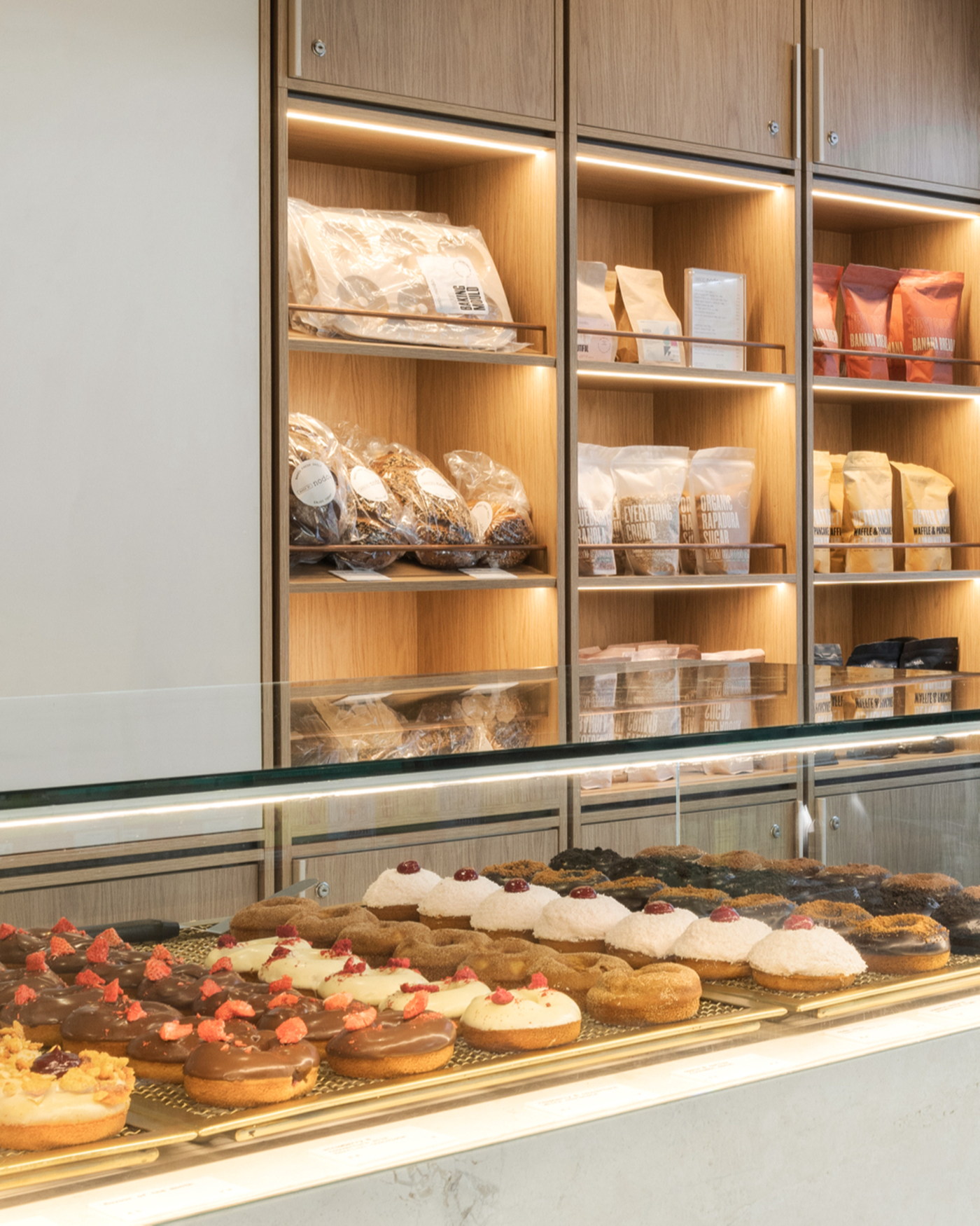 Counter filled with donuts and shelves in the background with bread and packets at Nodo Donuts Brisbane 