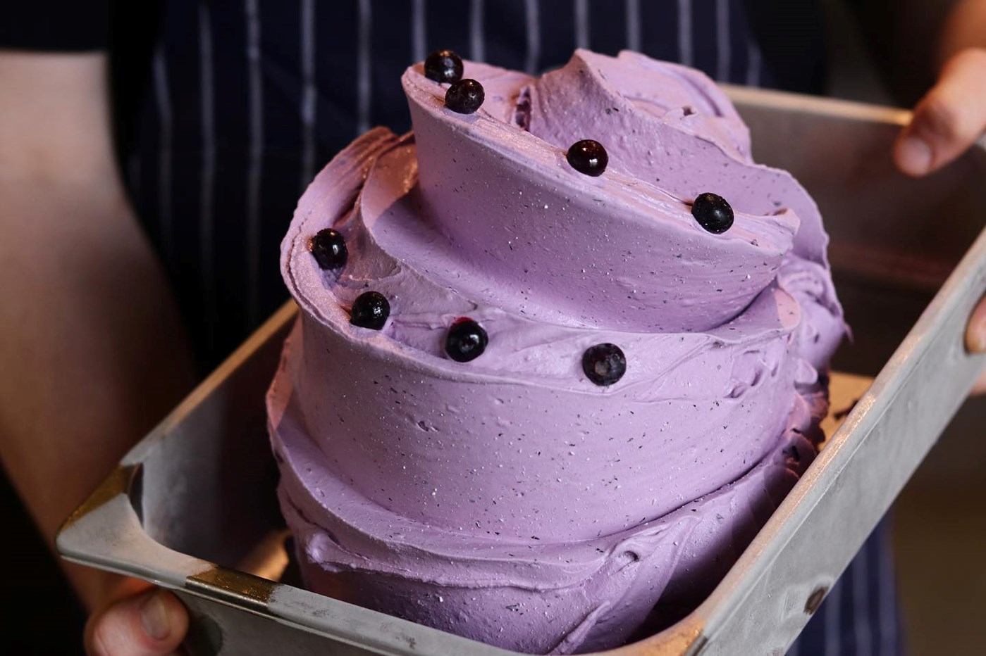 A large tub of purple-coloured gelato adorned with lollies. 