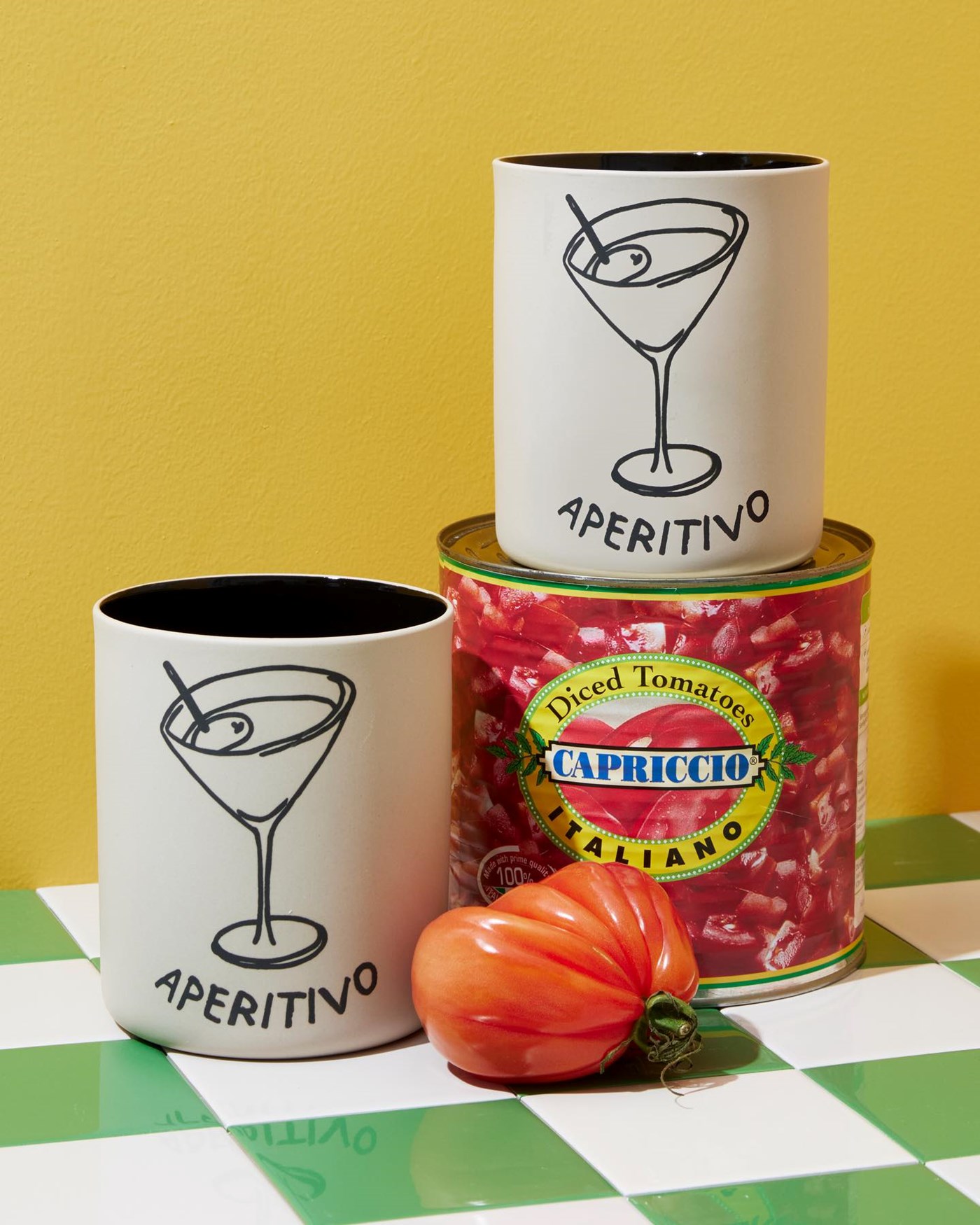Two cylindrical vessels with a martini drawn on the front above the words 'aperitivo' 