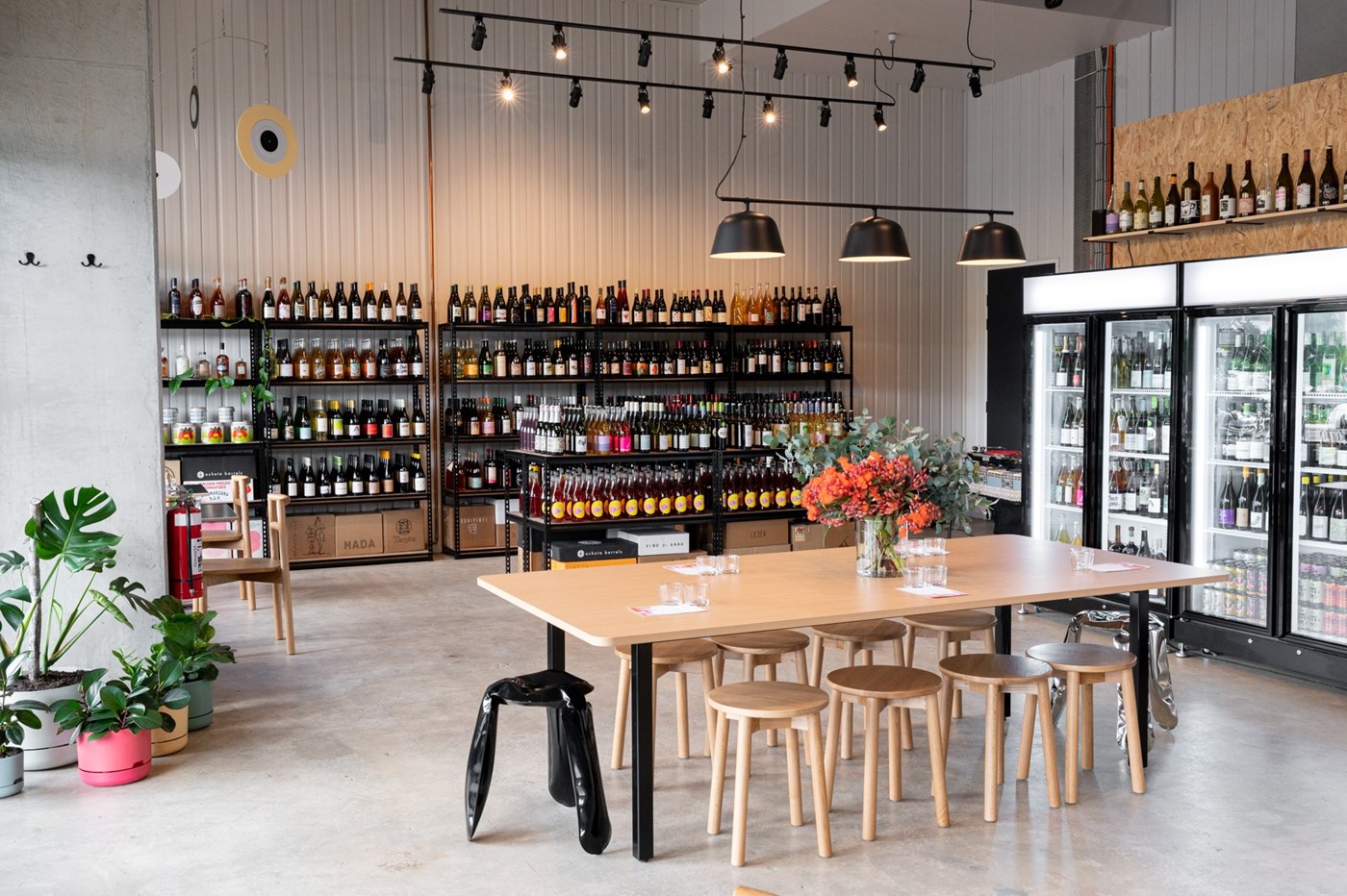 Interior of Paranormal Wines Canberra with racks and chilled shelves of wine; a long wooden table in the middle of the room