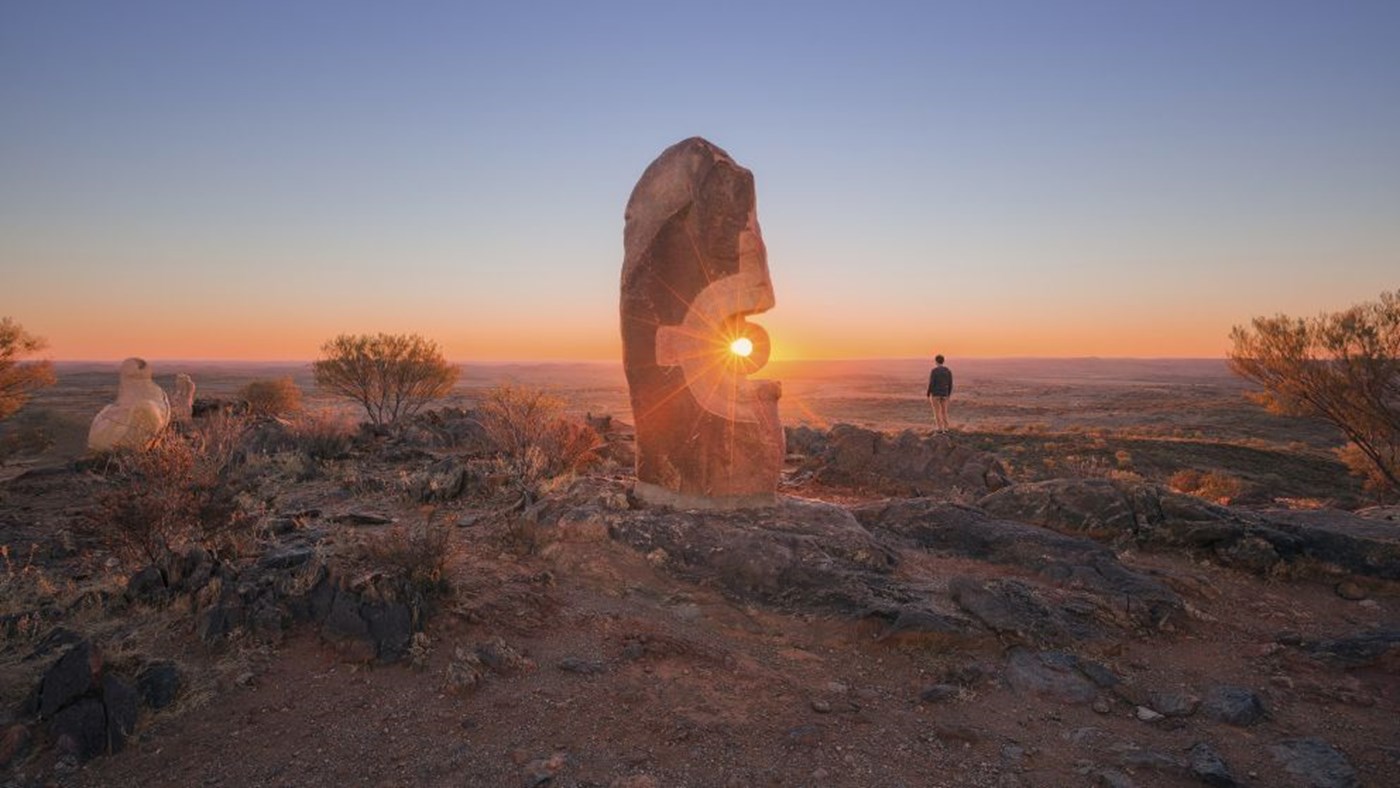 The sun peaks through a gap in a tall rock formation in Broken Hill creating a beautiful light illusion.