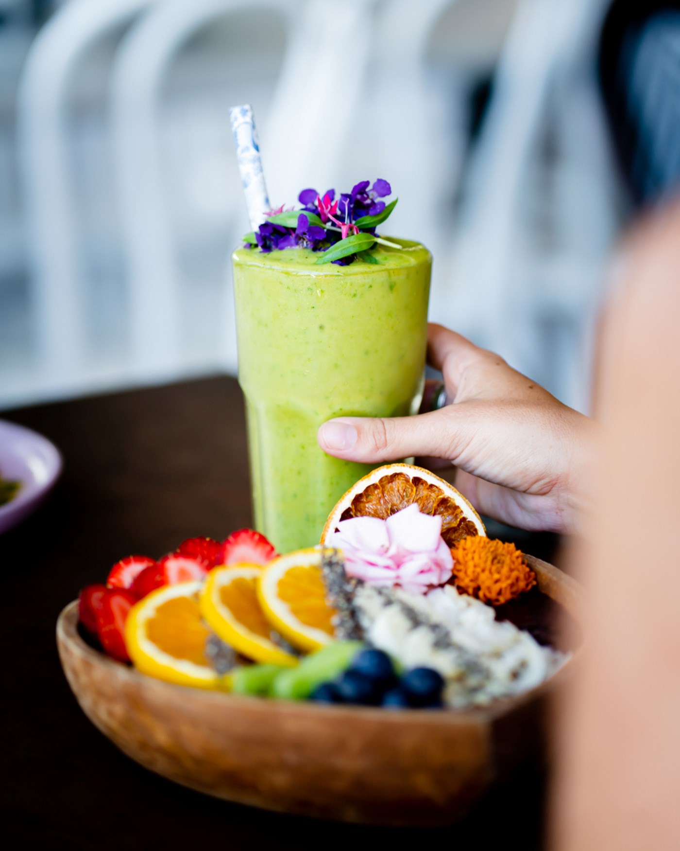 Acai fruit bowl and a green juice on a brown table