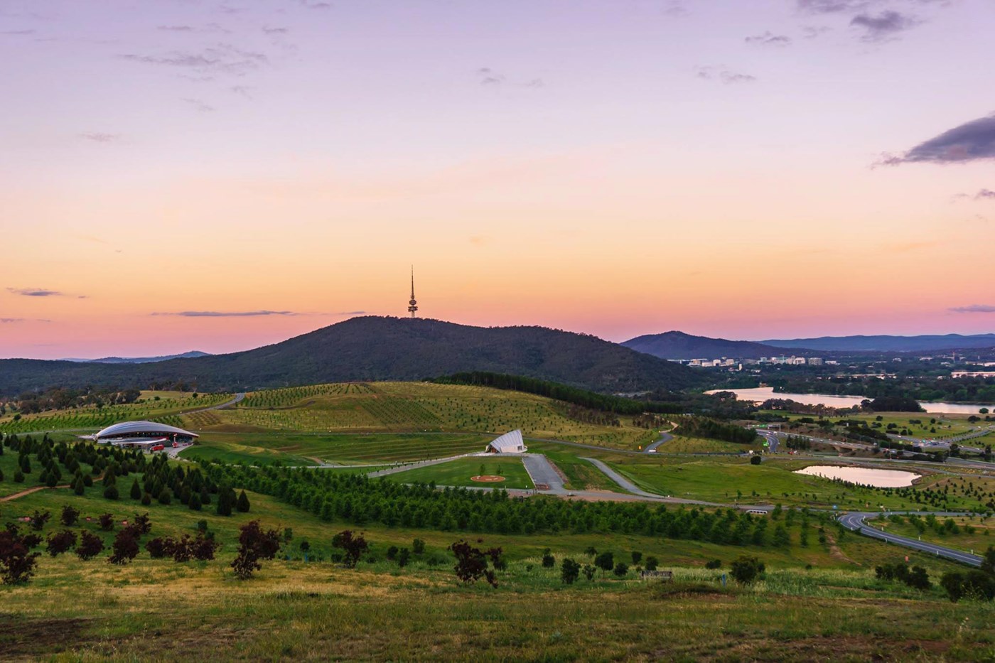 Landscape view of National Arboretum in Canberra at sunset with orange and pink sky