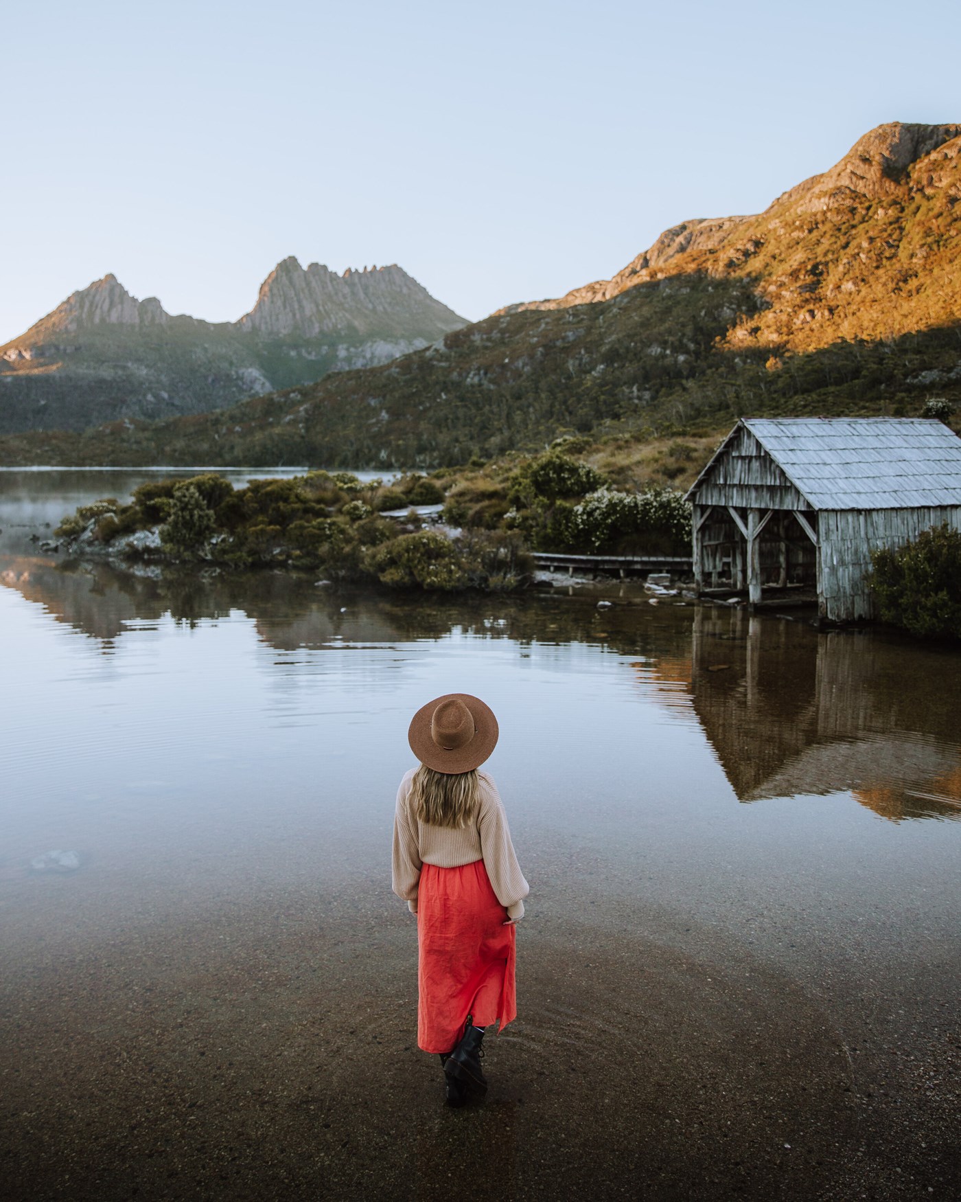 Woman wading in shallows at Cradle Mountain in Tasmania