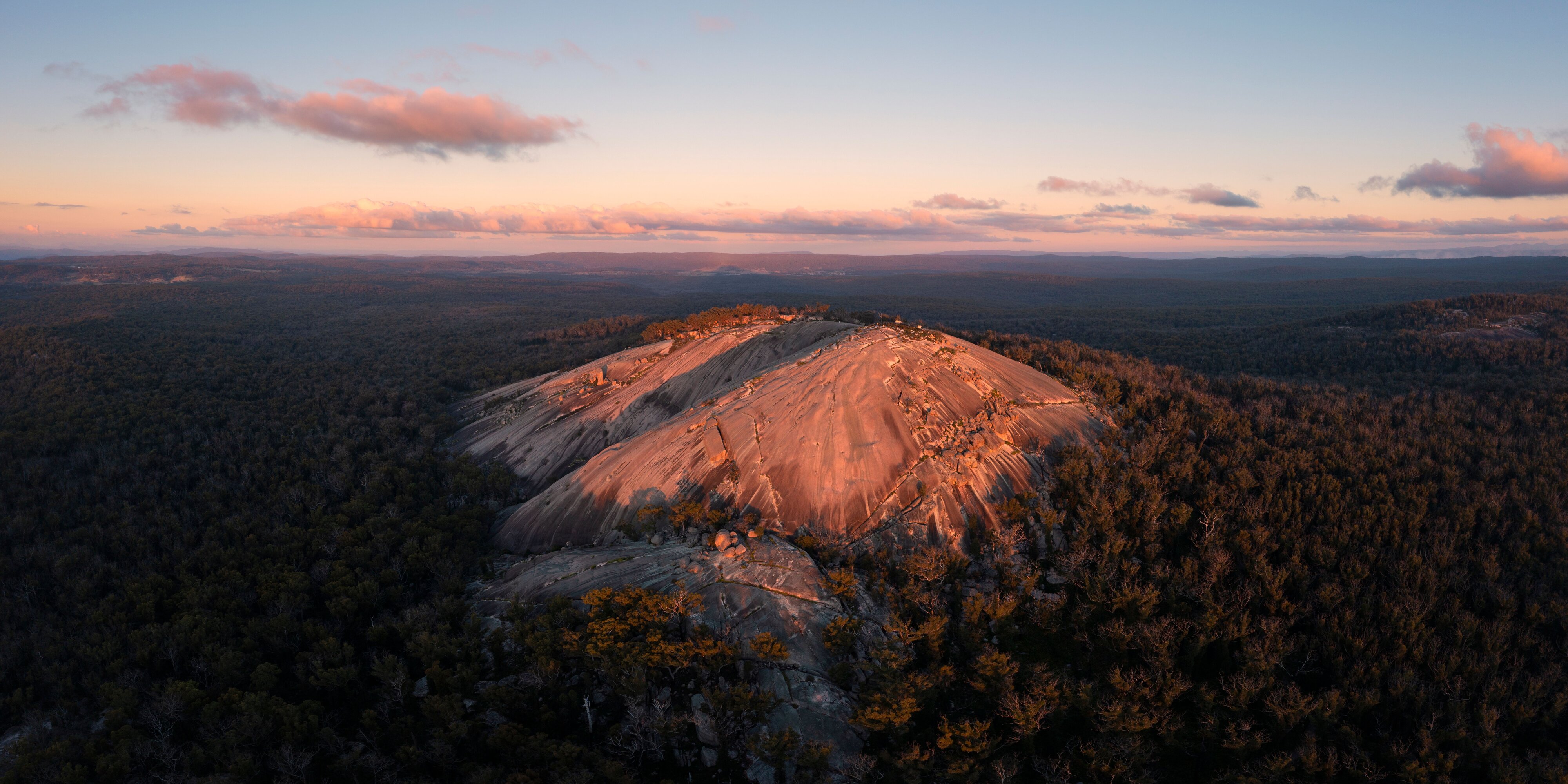 Sun setting over Bald Rock in Bald Rock National Park, Carrolls Creek. (Image Credit: Destination NSW)
