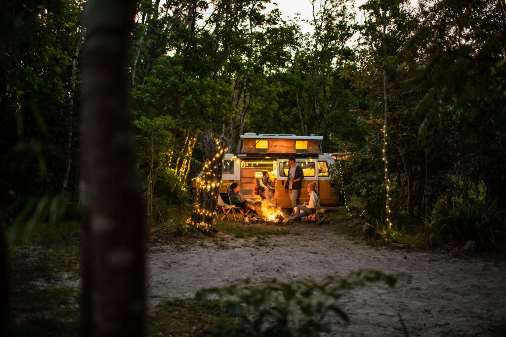 Young people relaxing by the campfire at Waves Campground in Crescent Head. (Image Credit: Destination NSW)