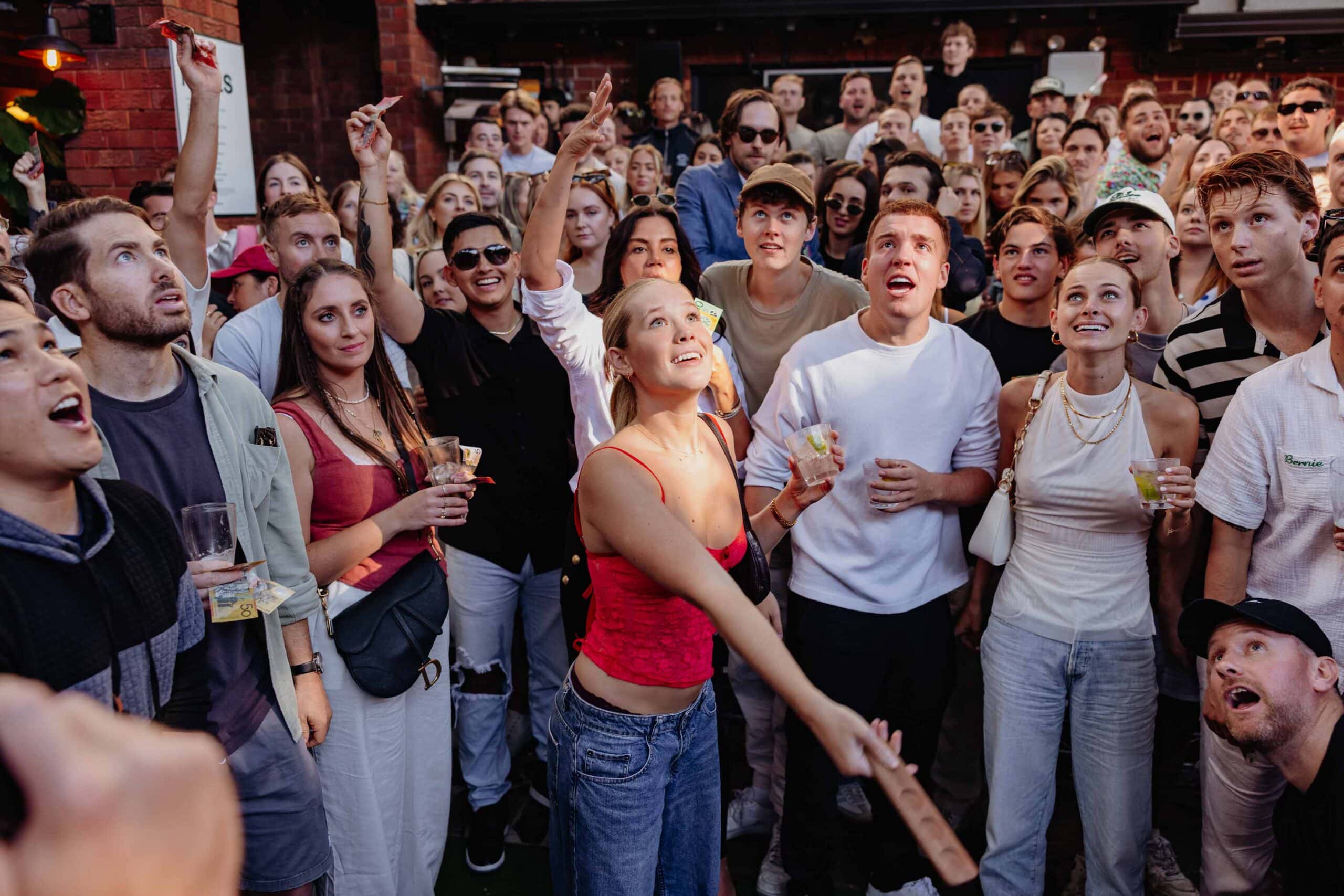 A woman plays two-up at The Golden Sheaf on Anzac Day