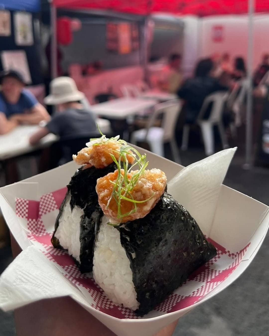 Two onigiri in a paper takeaway box at a food market in Brisbane.