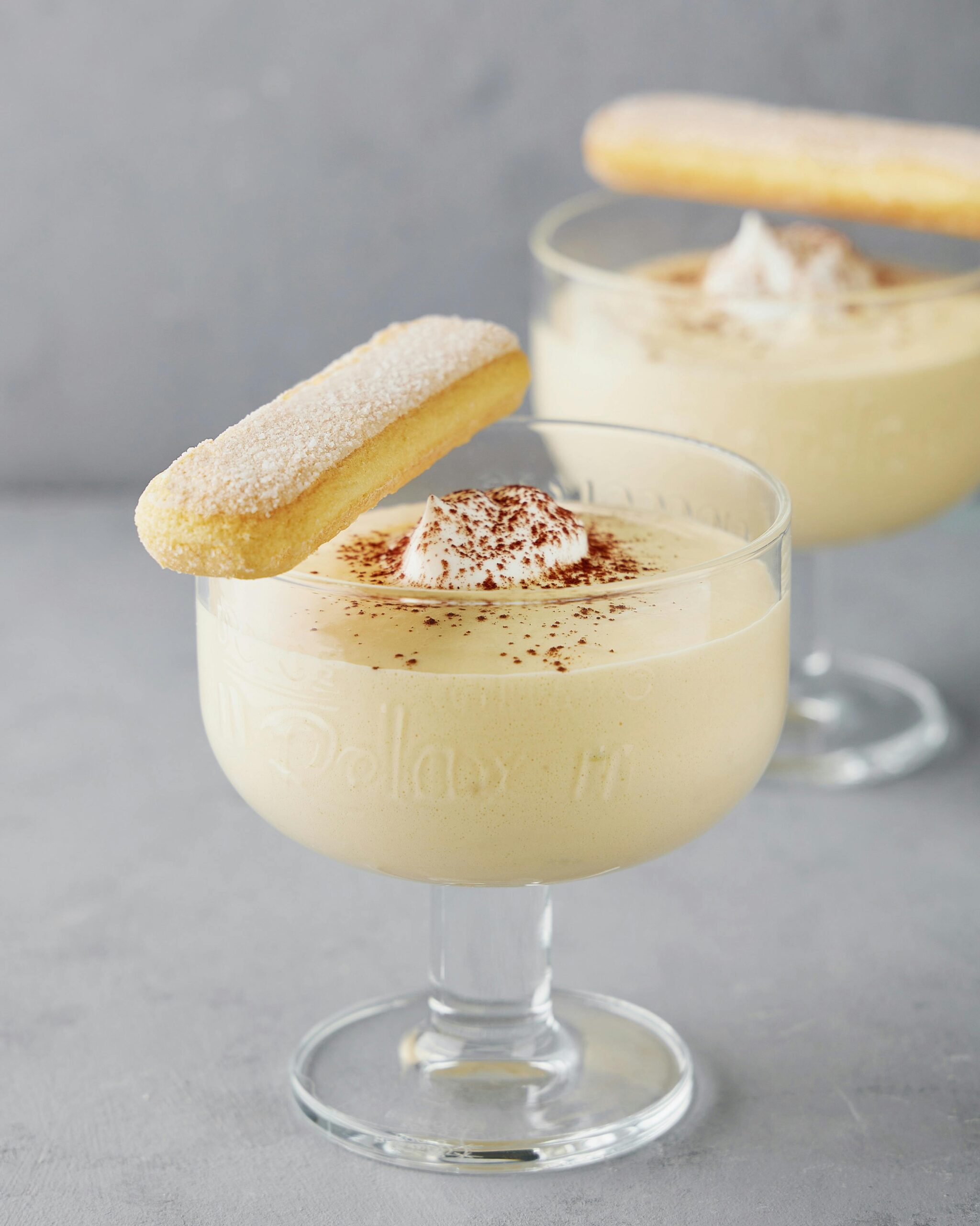 Panna cotta served in a dessert cup with a biscuit.