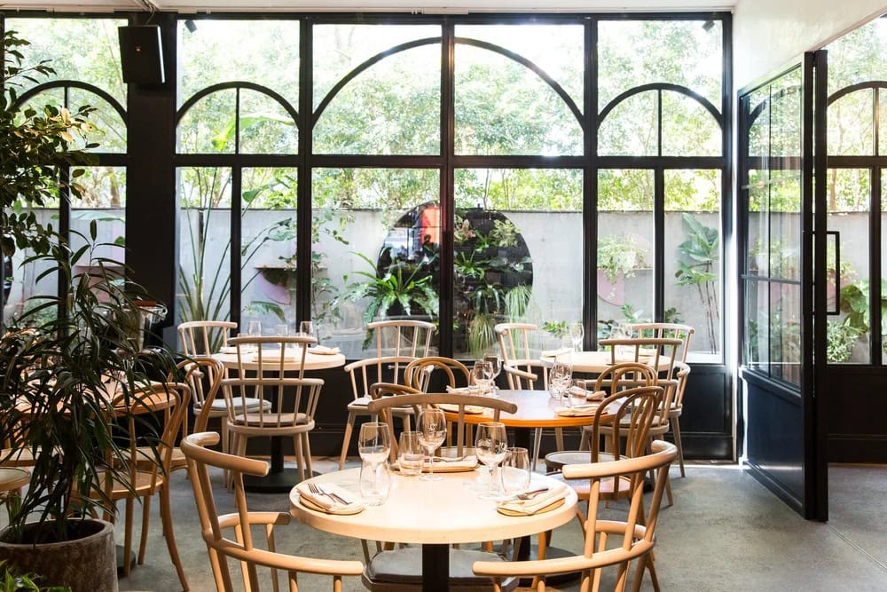 Dining room interior with arched steel windows and garden views at Nour Surry Hills Sydney