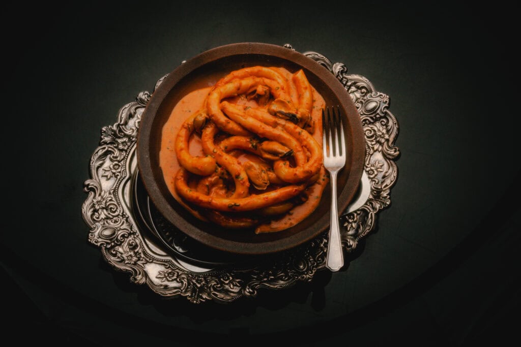 A silver plate of an extra big pasta noodle at attenzione!