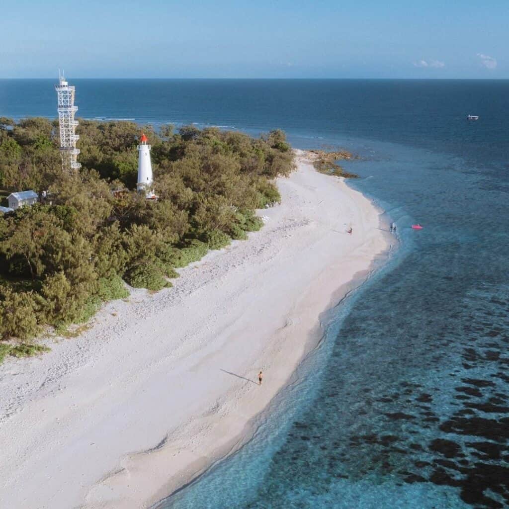 An aerial shot of someone walking along the sands on Lady Elliott Island.
