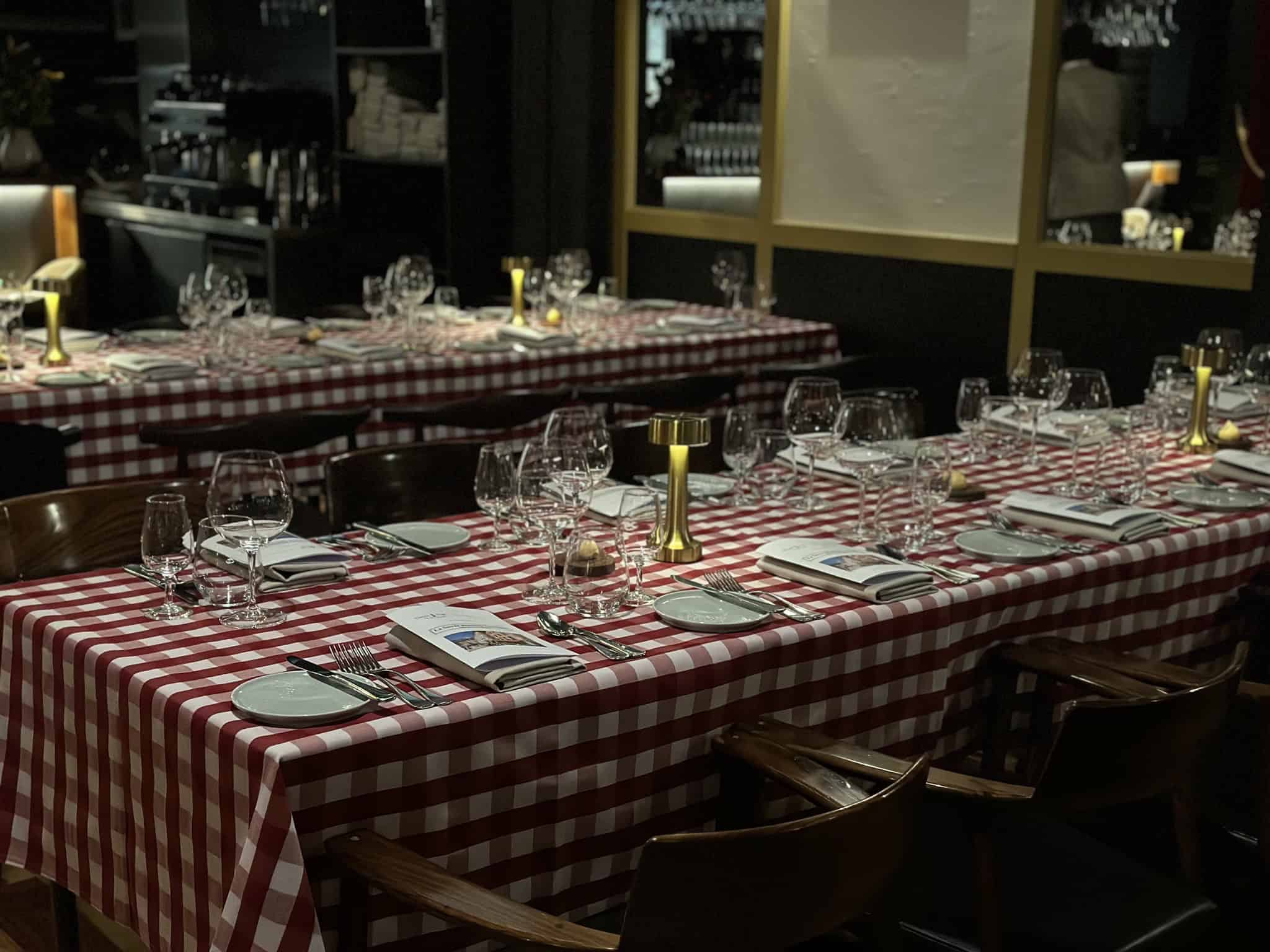 A long dining table with a chequered cloth.