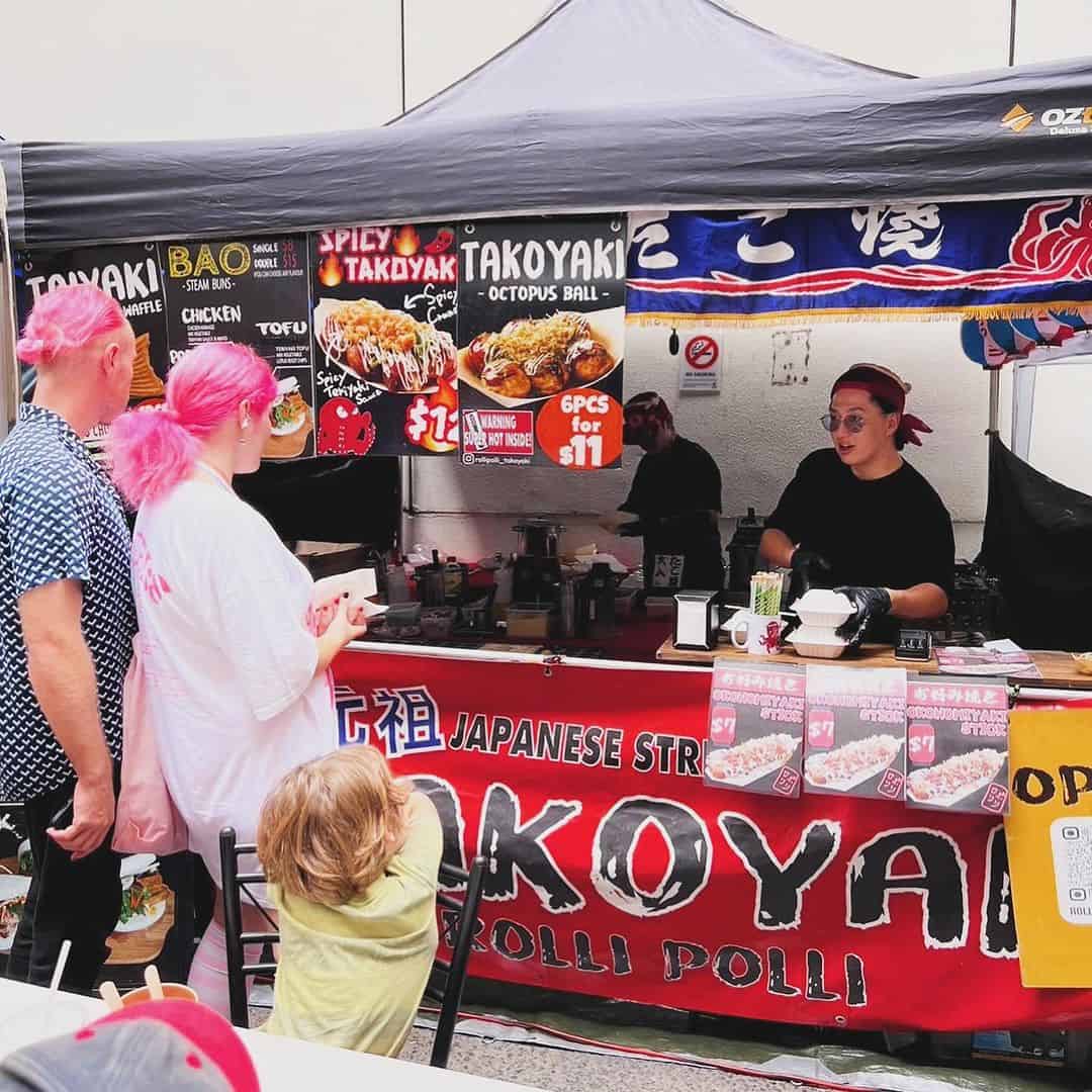 People working in a takoyaki food truck.