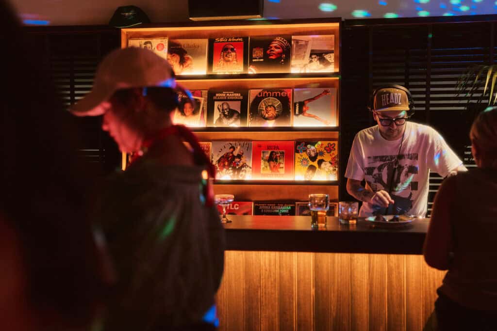 A DJ standing in front of a wall of vinyl at Baptist Street Rec Club in Redfern