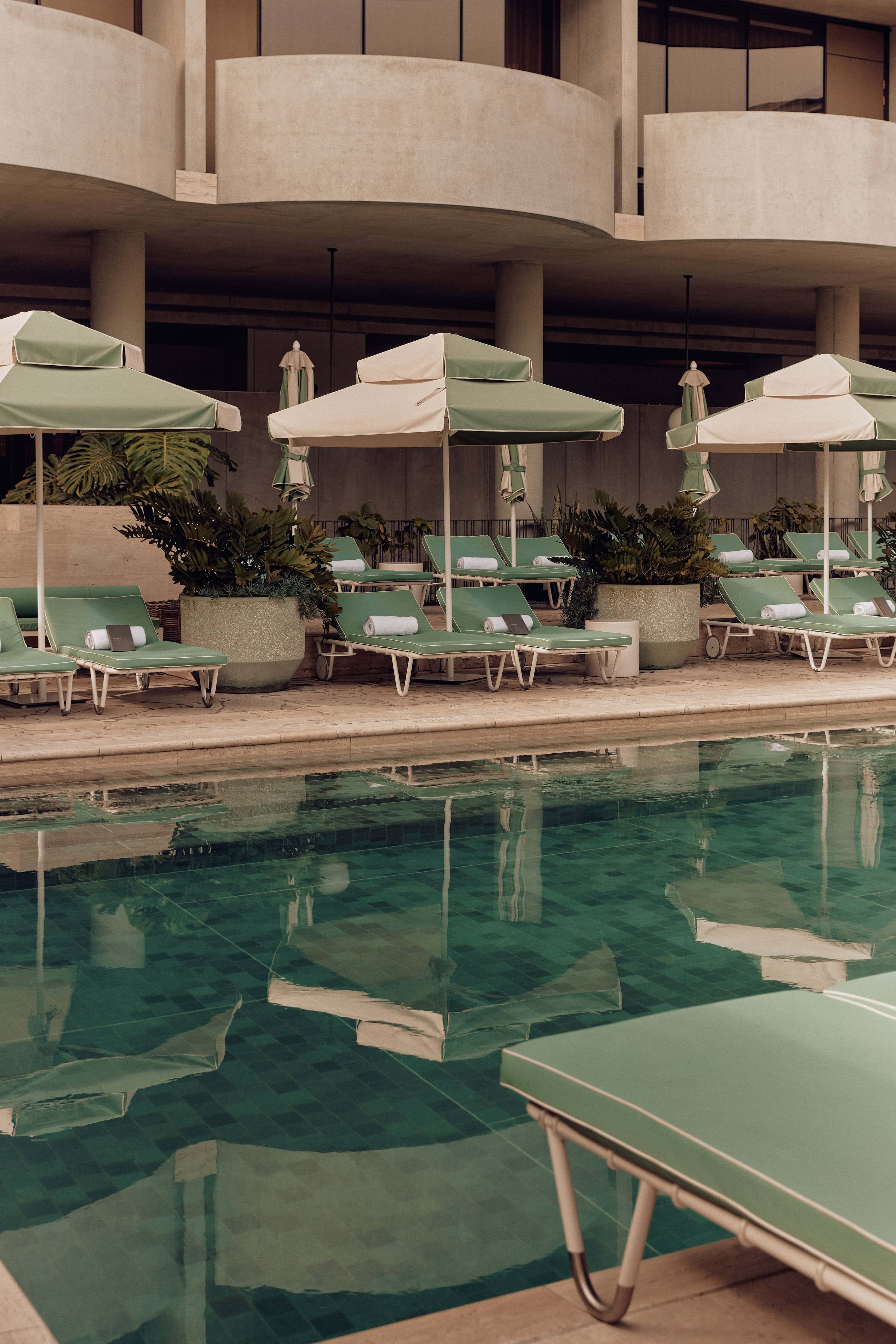 A view of the lilo chairs and umbrellas by a hotel pool.