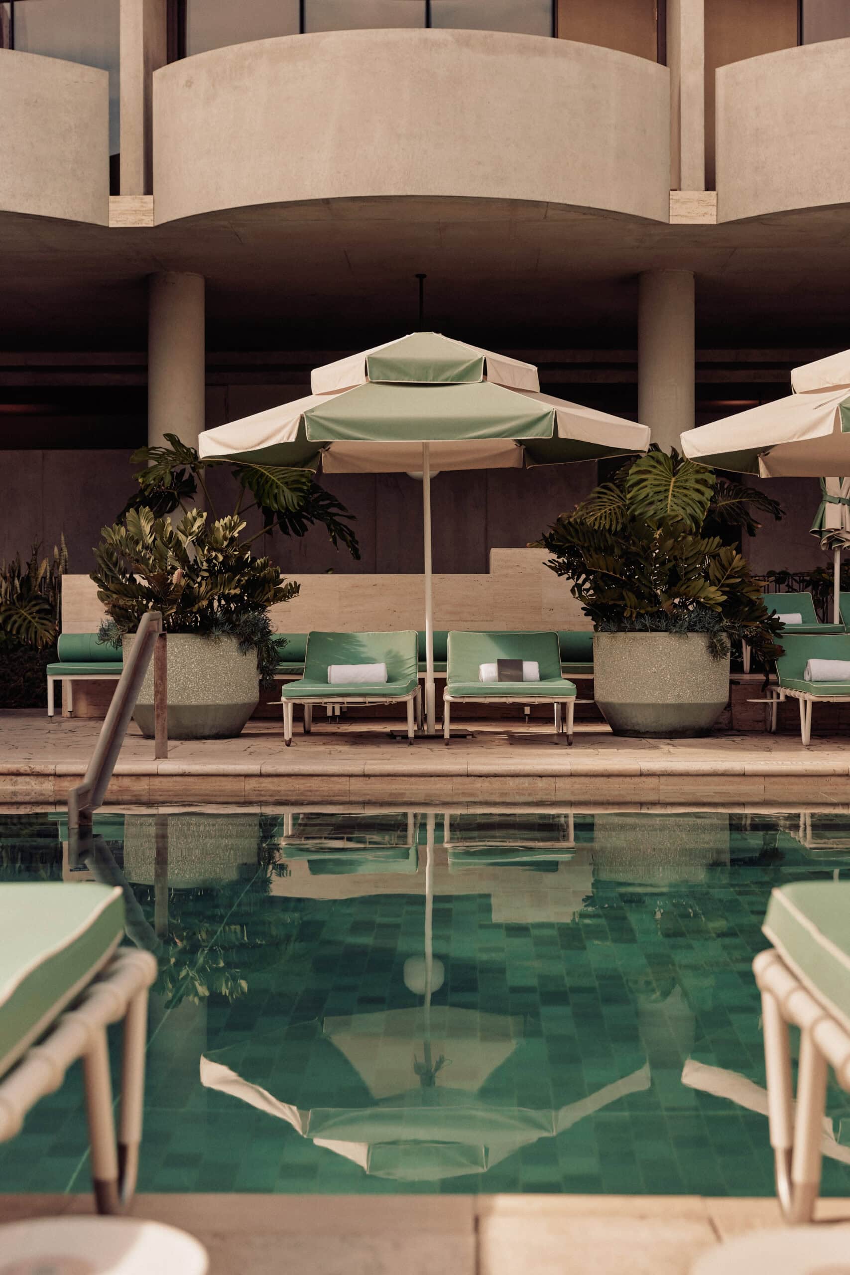 A view of li-lo chairs and umbrellas at a hotel pool.