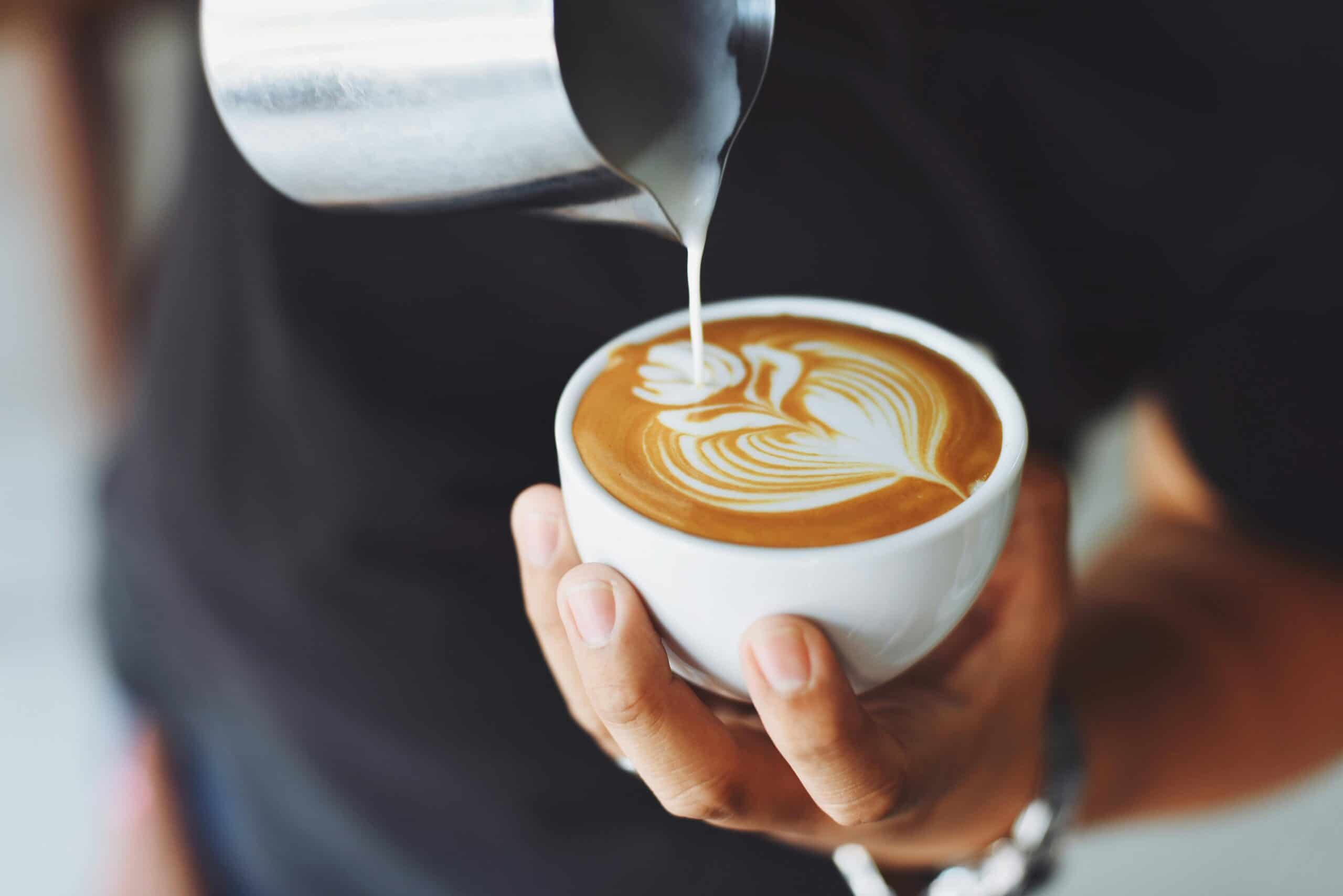 Coffee art is displayed on a fresh cup of coffee.