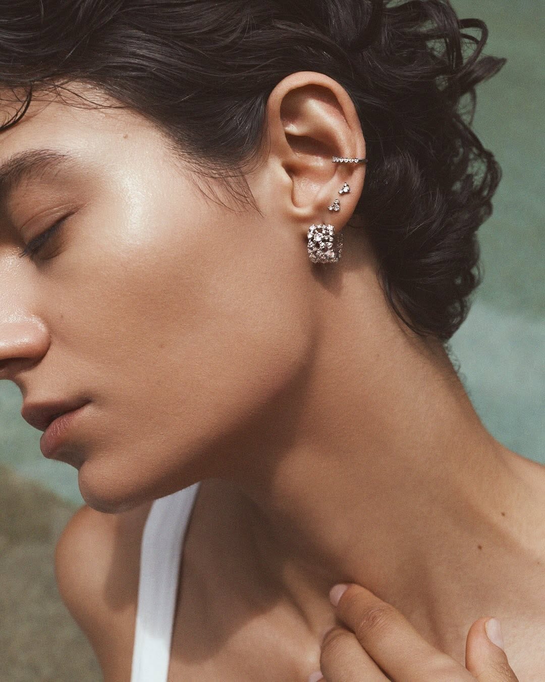 A woman shows off a four piercings on her ear