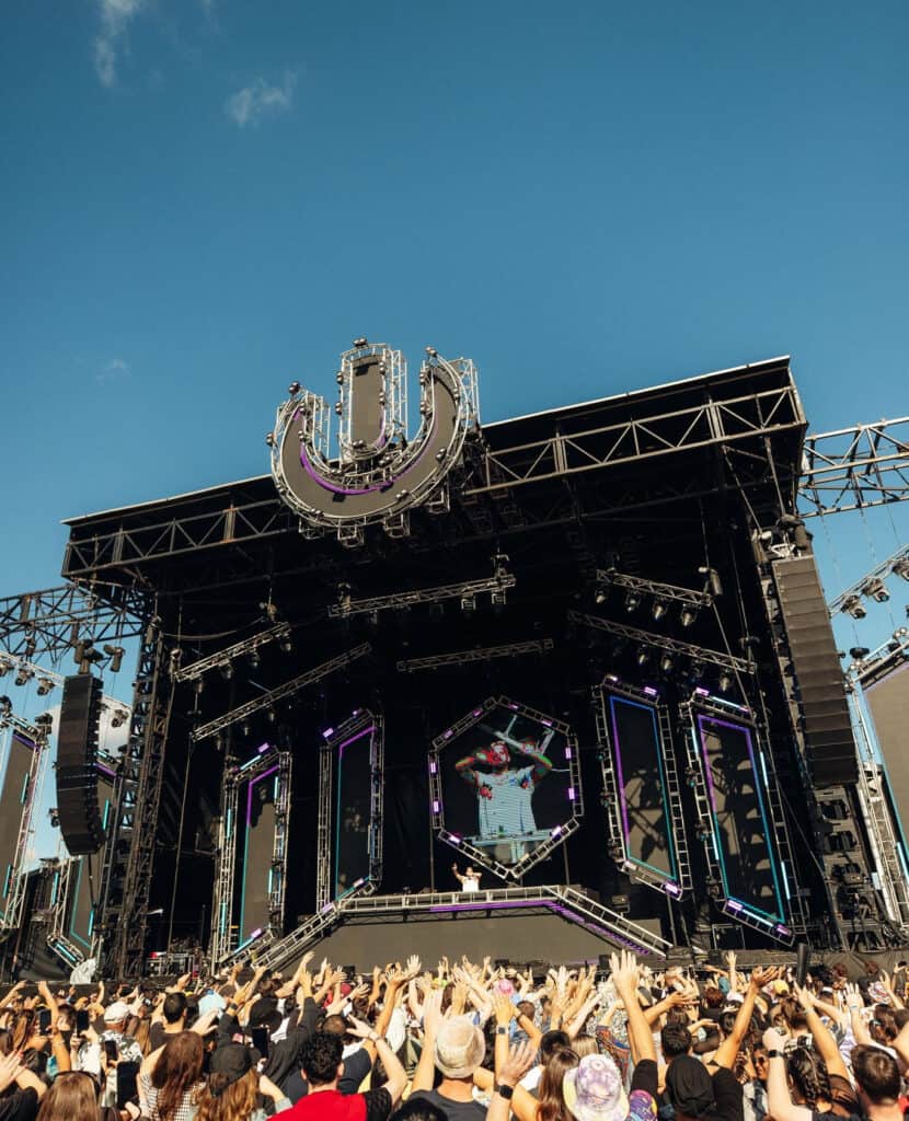 A large crowd in front of a DJ.