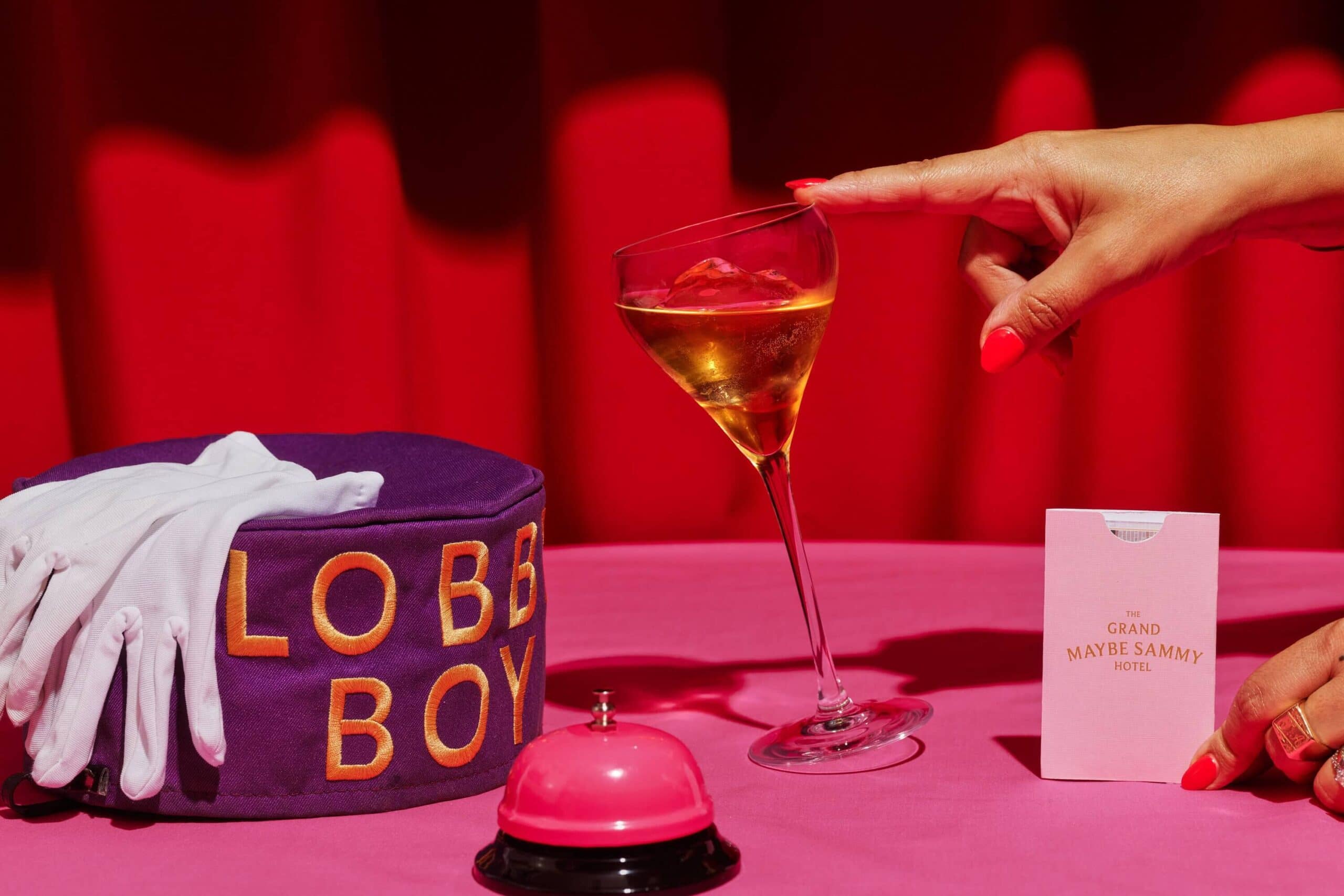 Cocktail featured in a concierge scene with lobby boy hat and room key. 