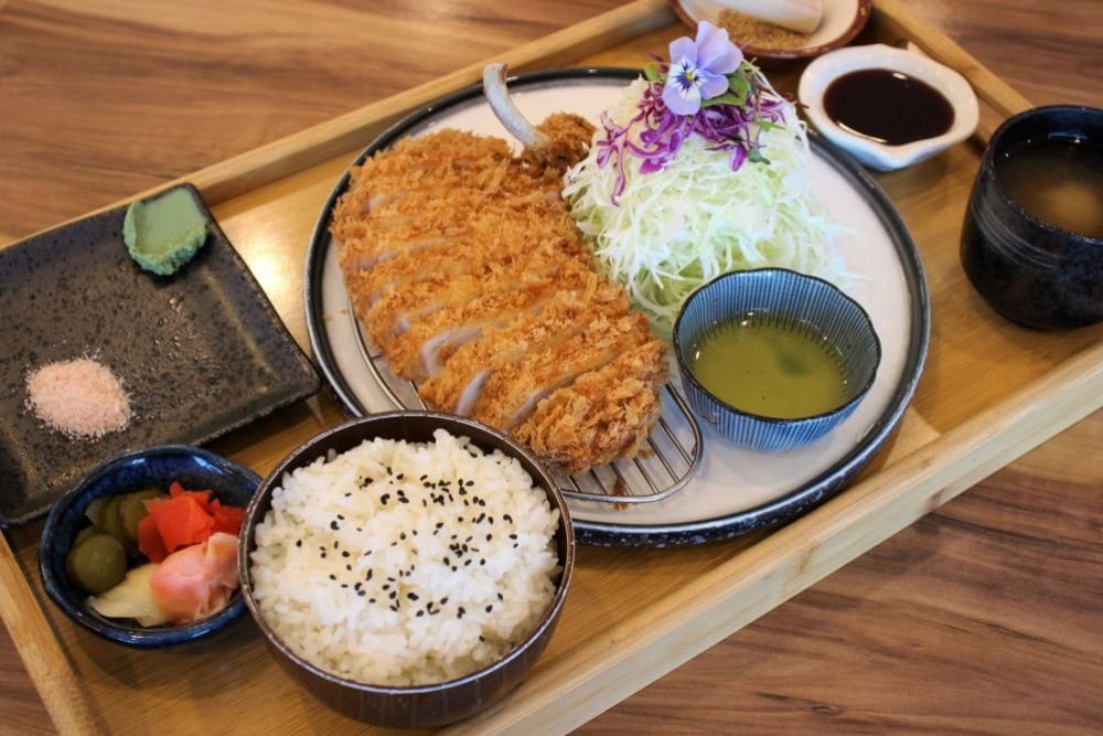 A Japanese katsu set meal with rice and pickles.