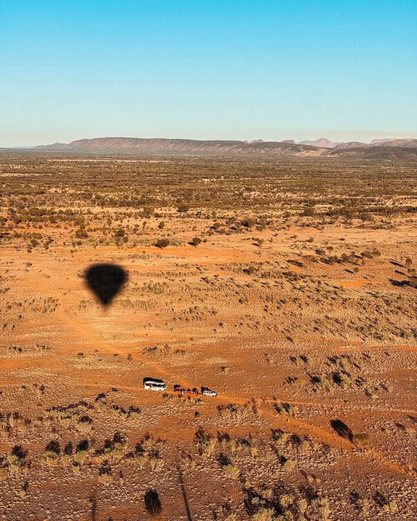 Shadow of hot air ballon trailing over outback