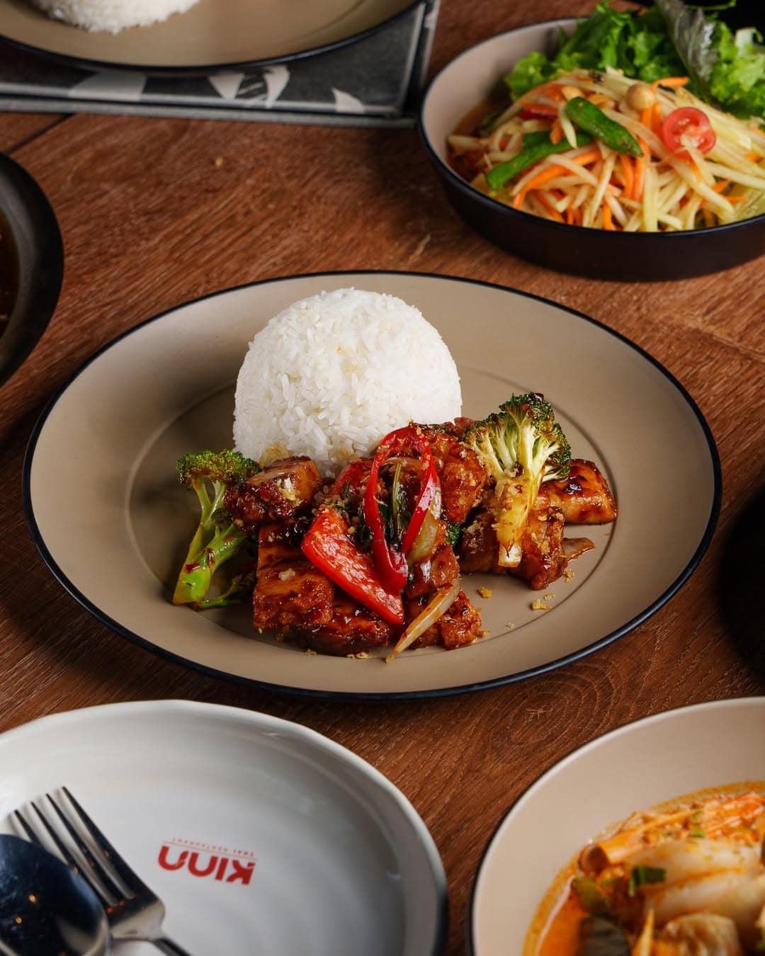 Thai food share plates on a table.