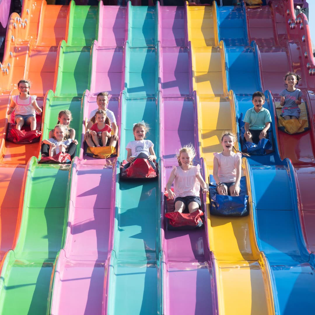 Children slide down colourful slides