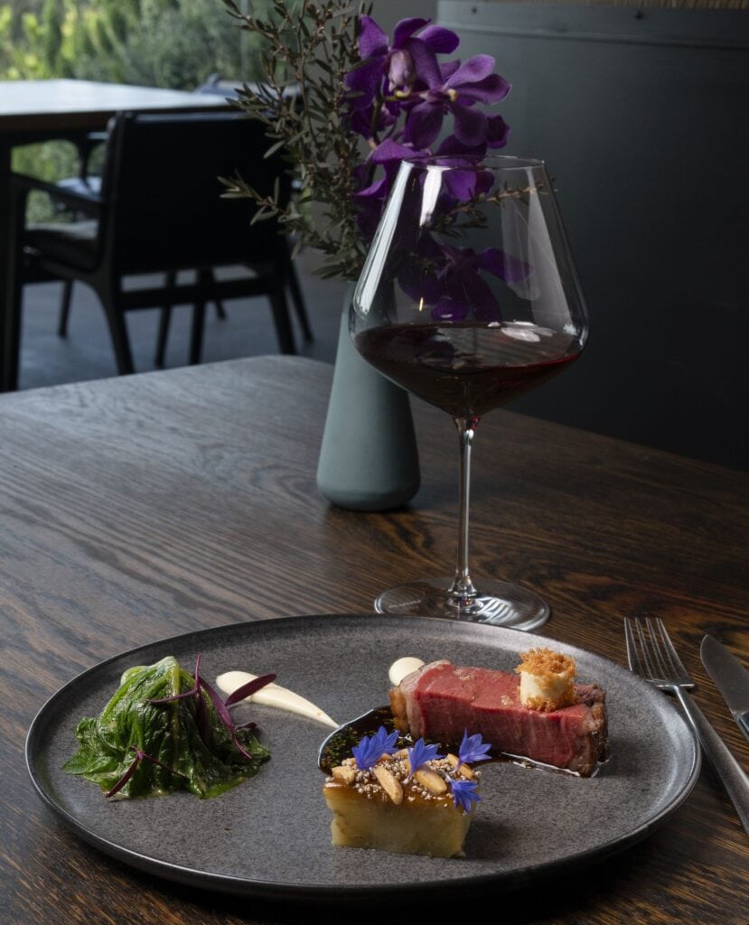glass of red wine and main dish at ten minutes by tractor mornington peninsula