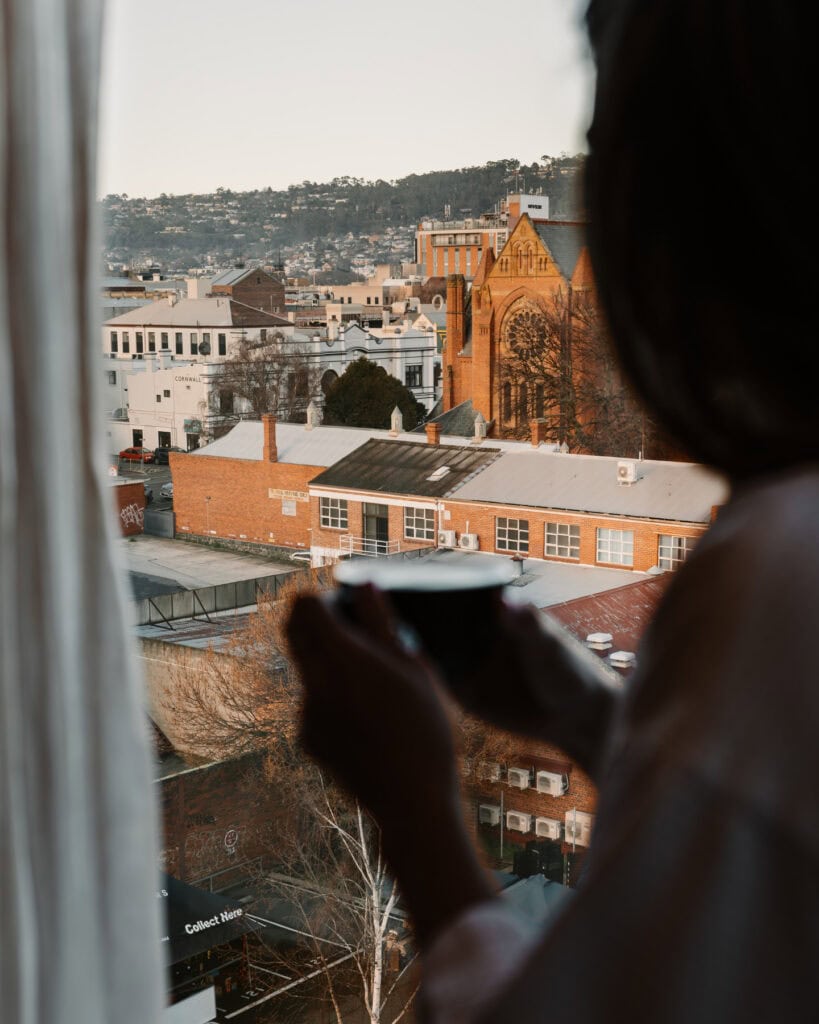 hotel verge person looking out window with coffee in hand at hotel verge launceston accommodation 
