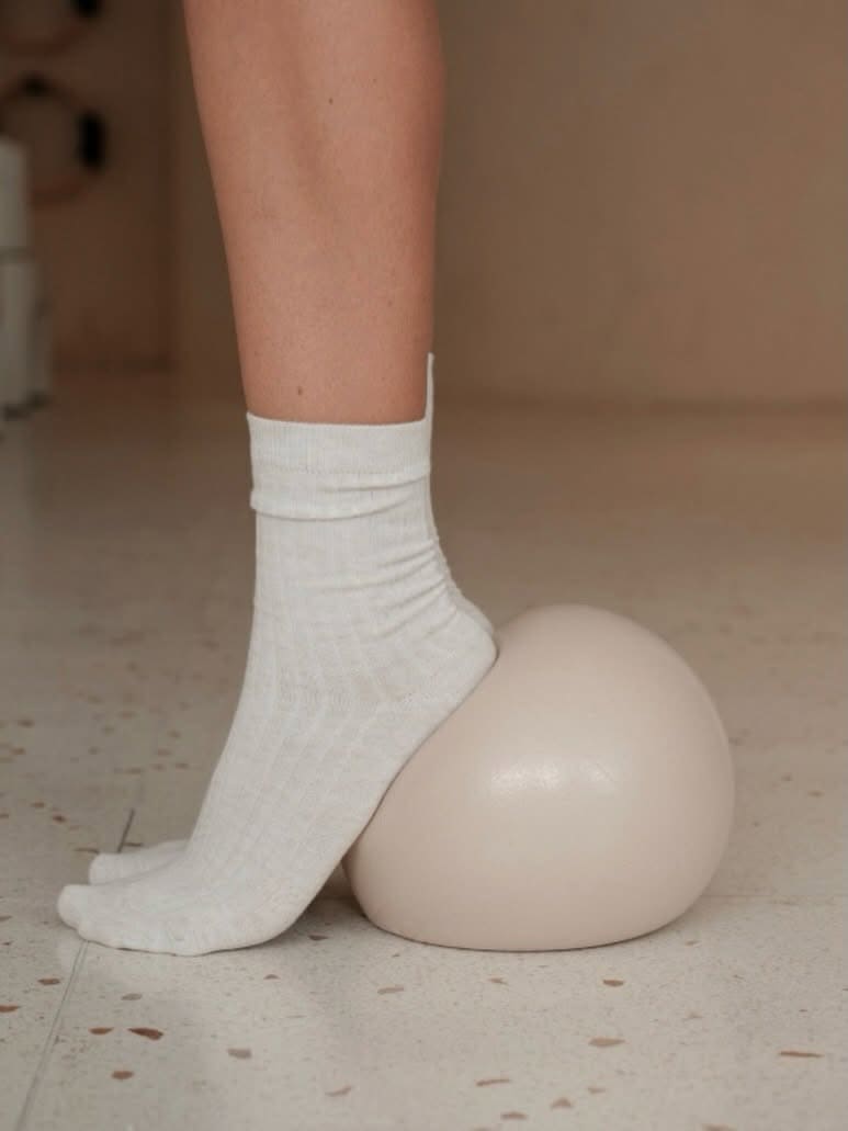 Close-up of a socked foot resting beside a Pilates ball at Yoga Corner