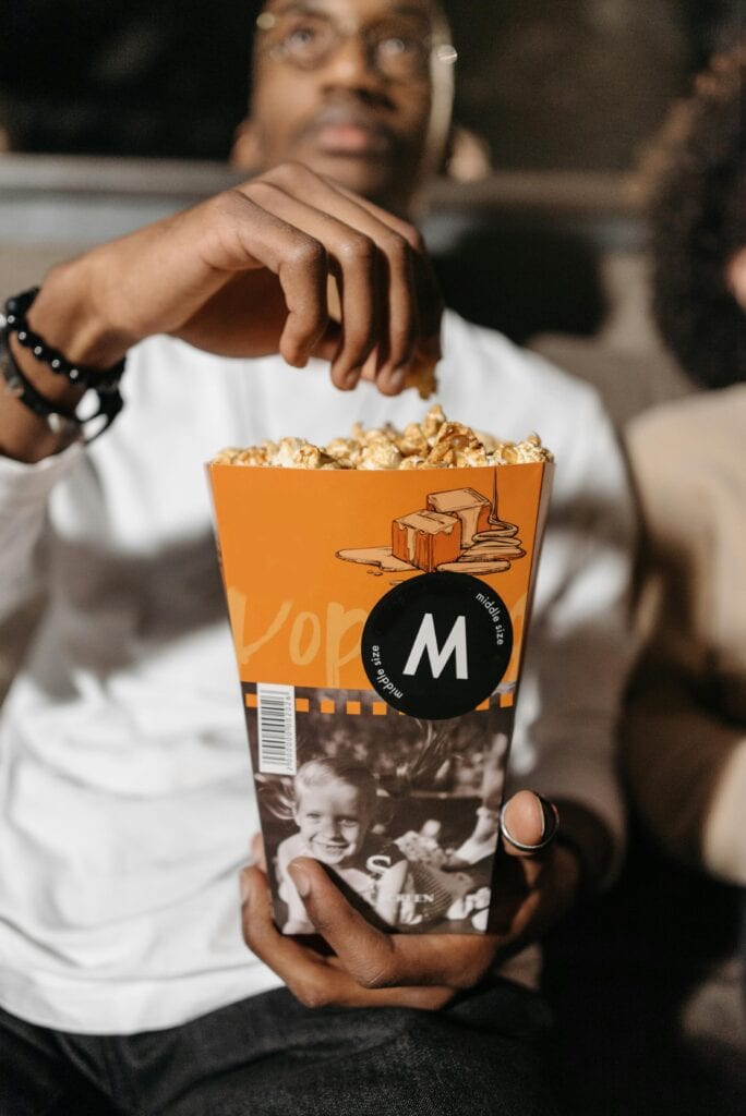 man grabbing popcorn