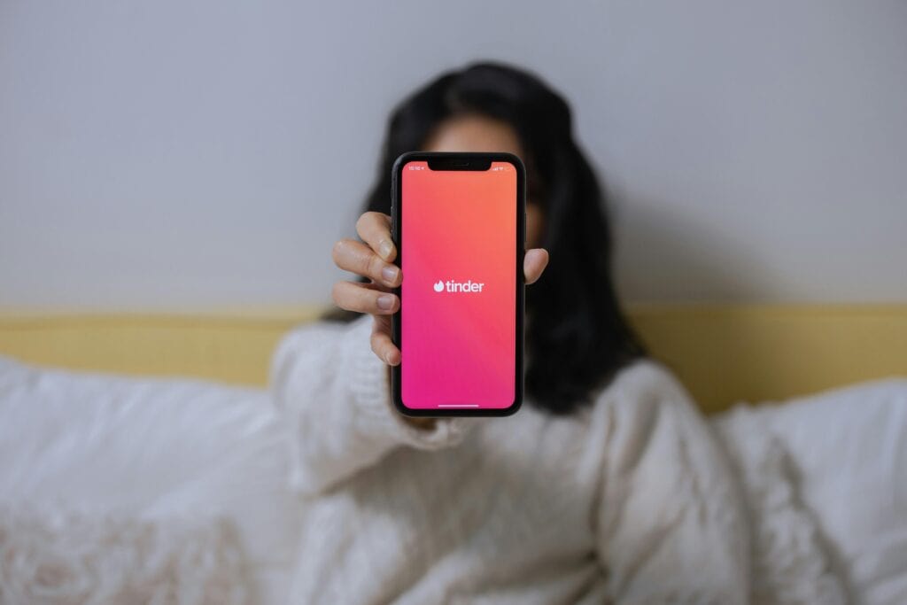 A woman shows her Tinder app on her smartphone