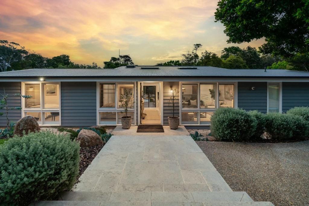 Hiraeth luxury holiday home in Mount Martha, Mornington Peninsula, beneath a pastel sunset sky.