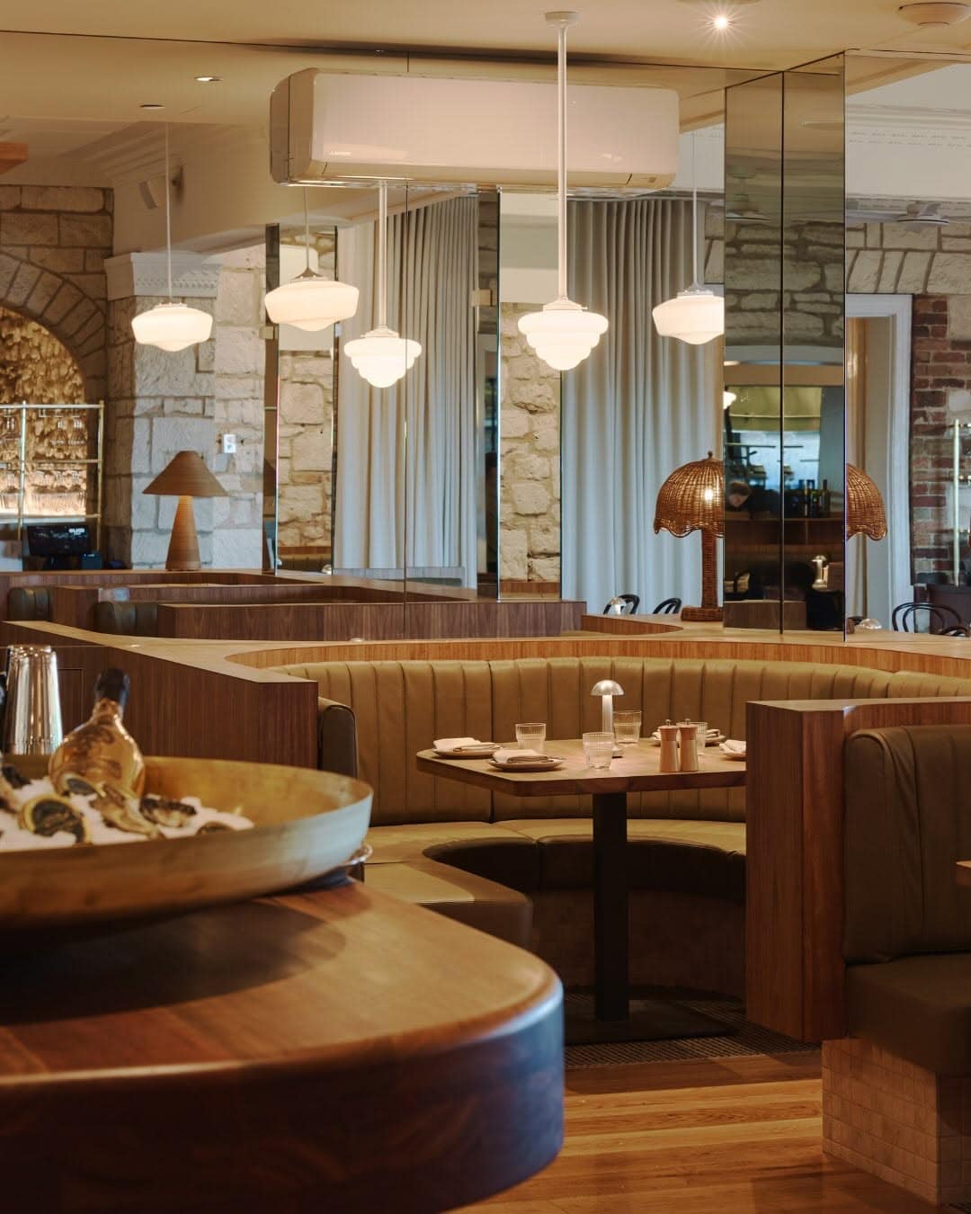 Newly refurbished Hotel Sorrento dining room featuring caramel leather banquettes, warm timber finishes, pendant lighting and heritage limestone walls.