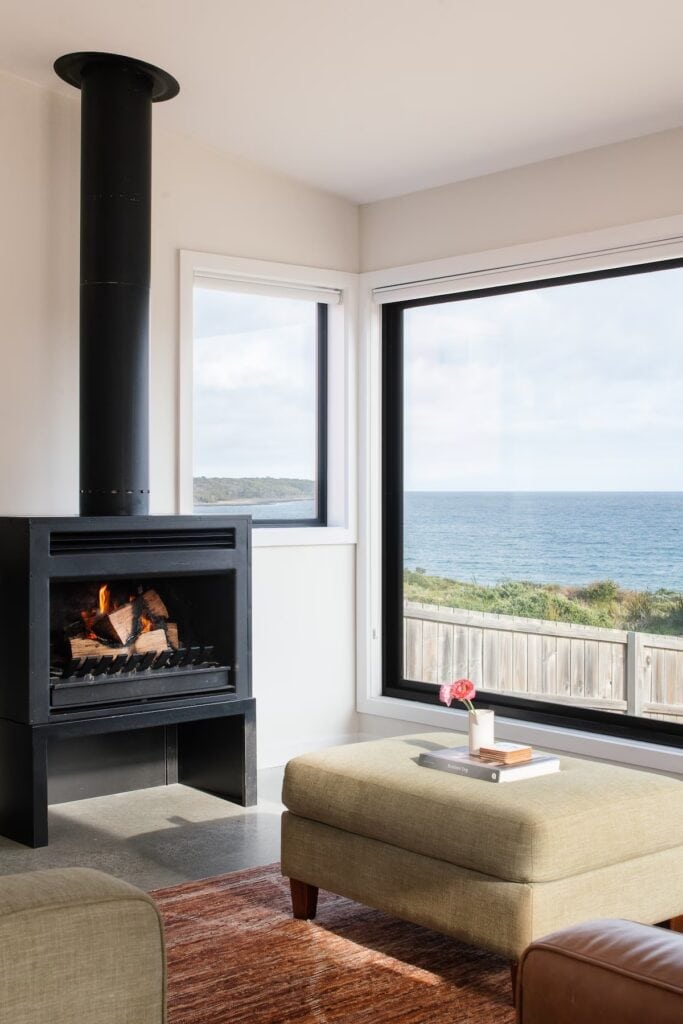 the living room with fireplace at tamo an airbnb in lulworth tasmania near bridport
