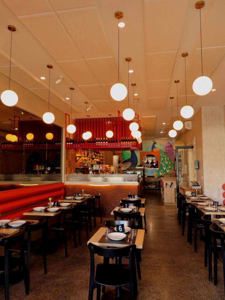 Interior of Thaali Indian Restaurant in Fairfield, Melbourne, with colourful seating, patterned details and a contemporary Indian dining room setting.