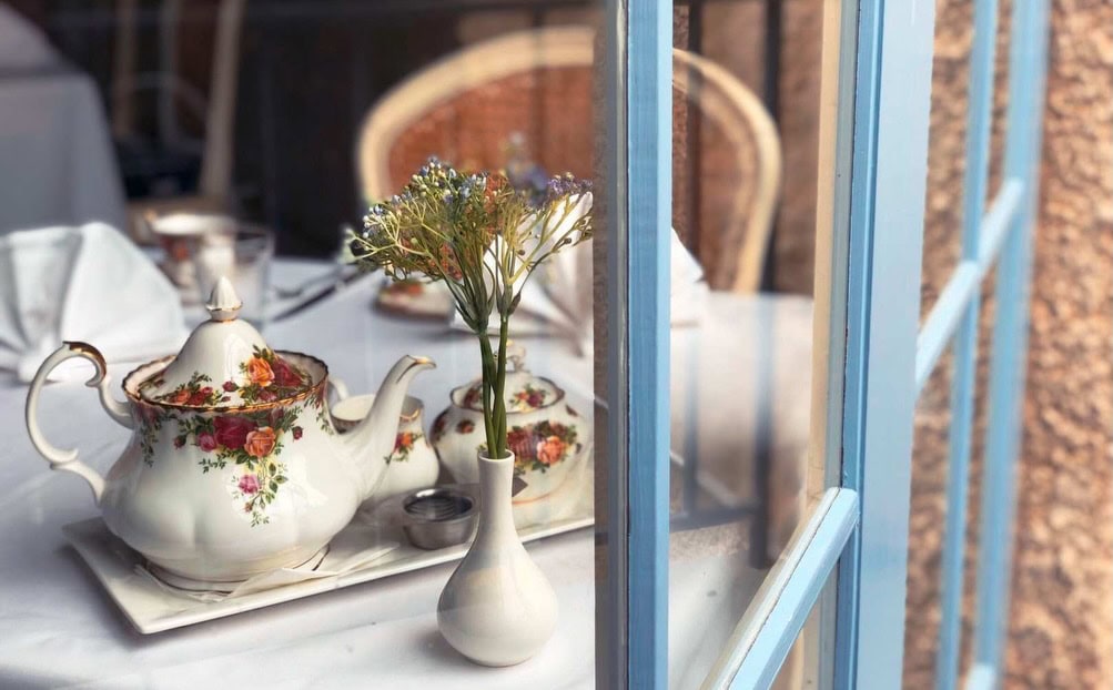 Floral teapot and table setting beside an open window at Villa Howden near Hobart.