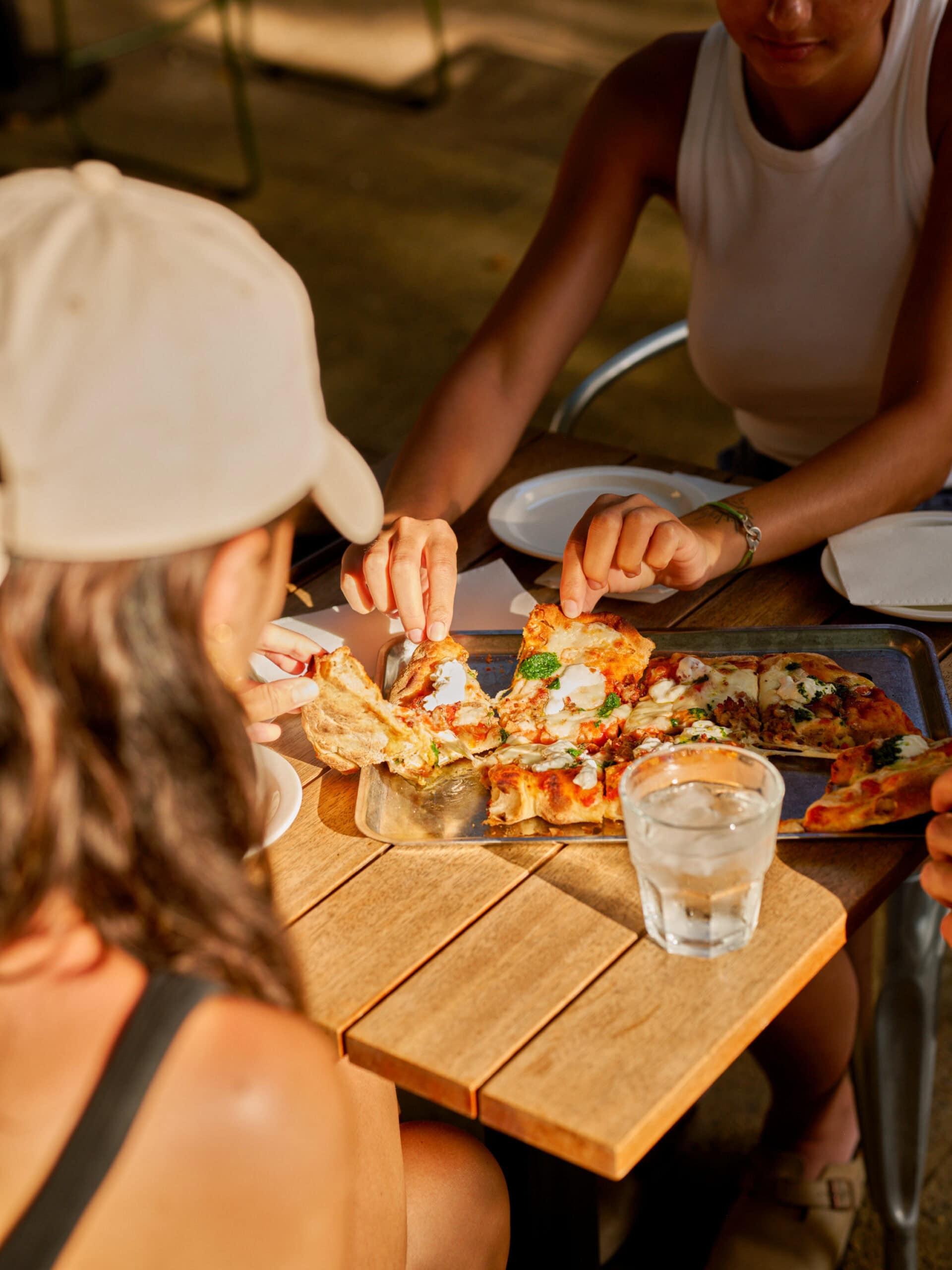 two girls eating a pizza at captain cook hotel laneway beer garden