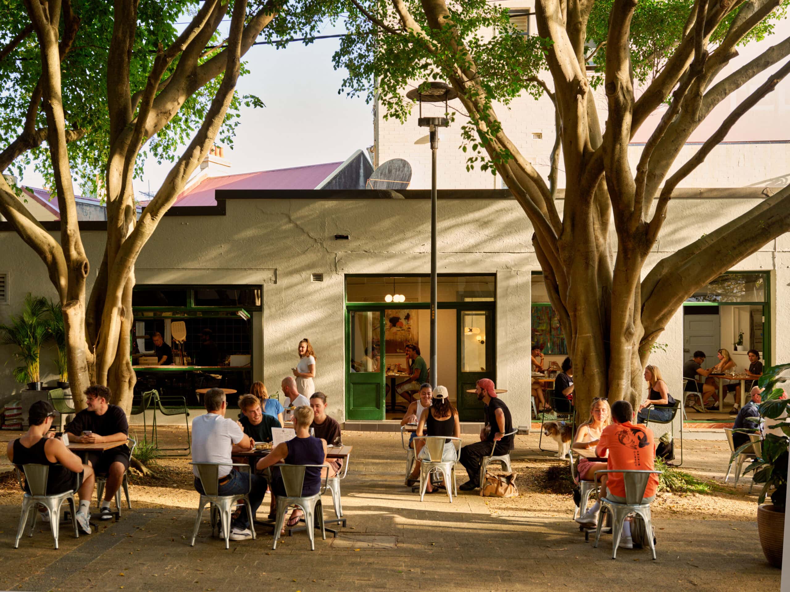 people sitting outside eating and drinking at the beer garden at captain cook hotel paddington